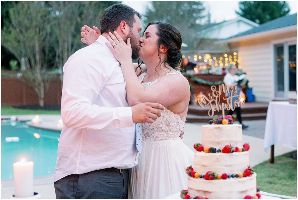 Couple kissing in front of wedding cake