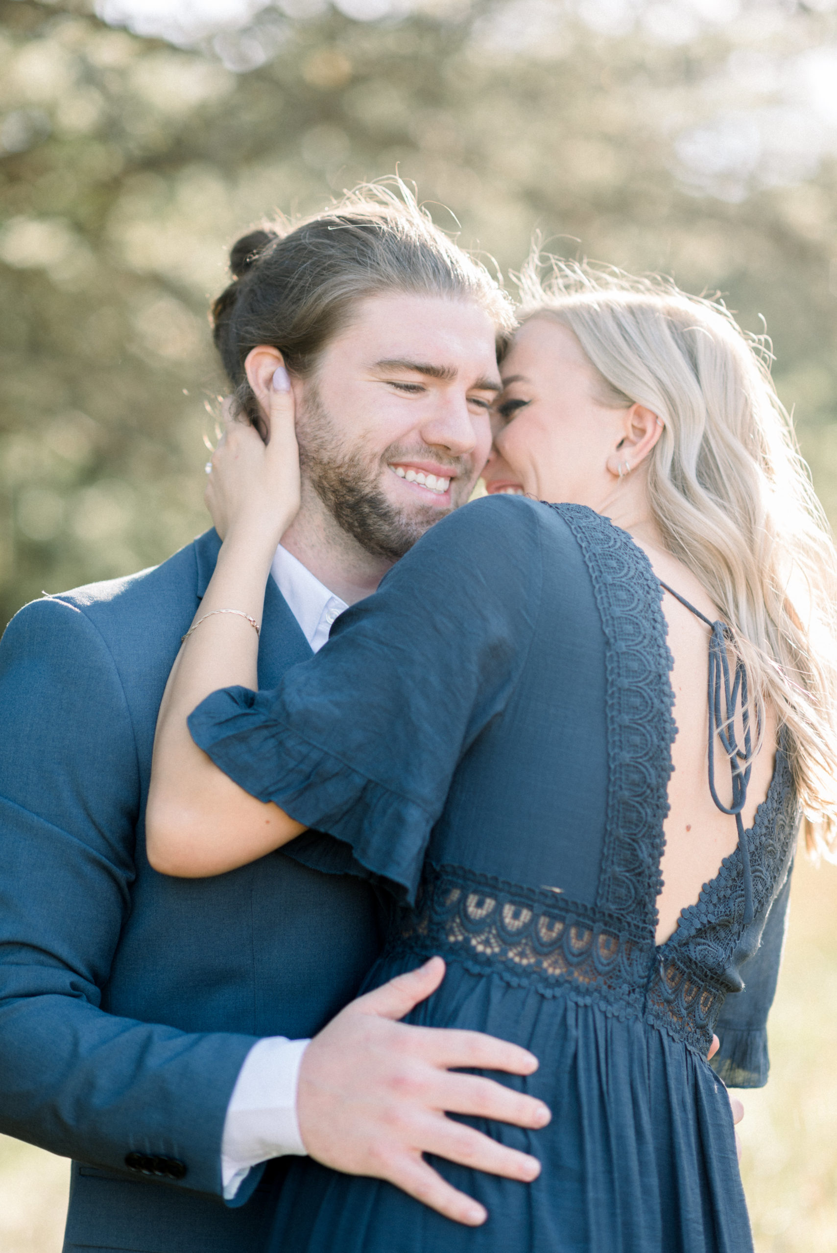 newly engaged couple laughing and embracing during engagement portraits