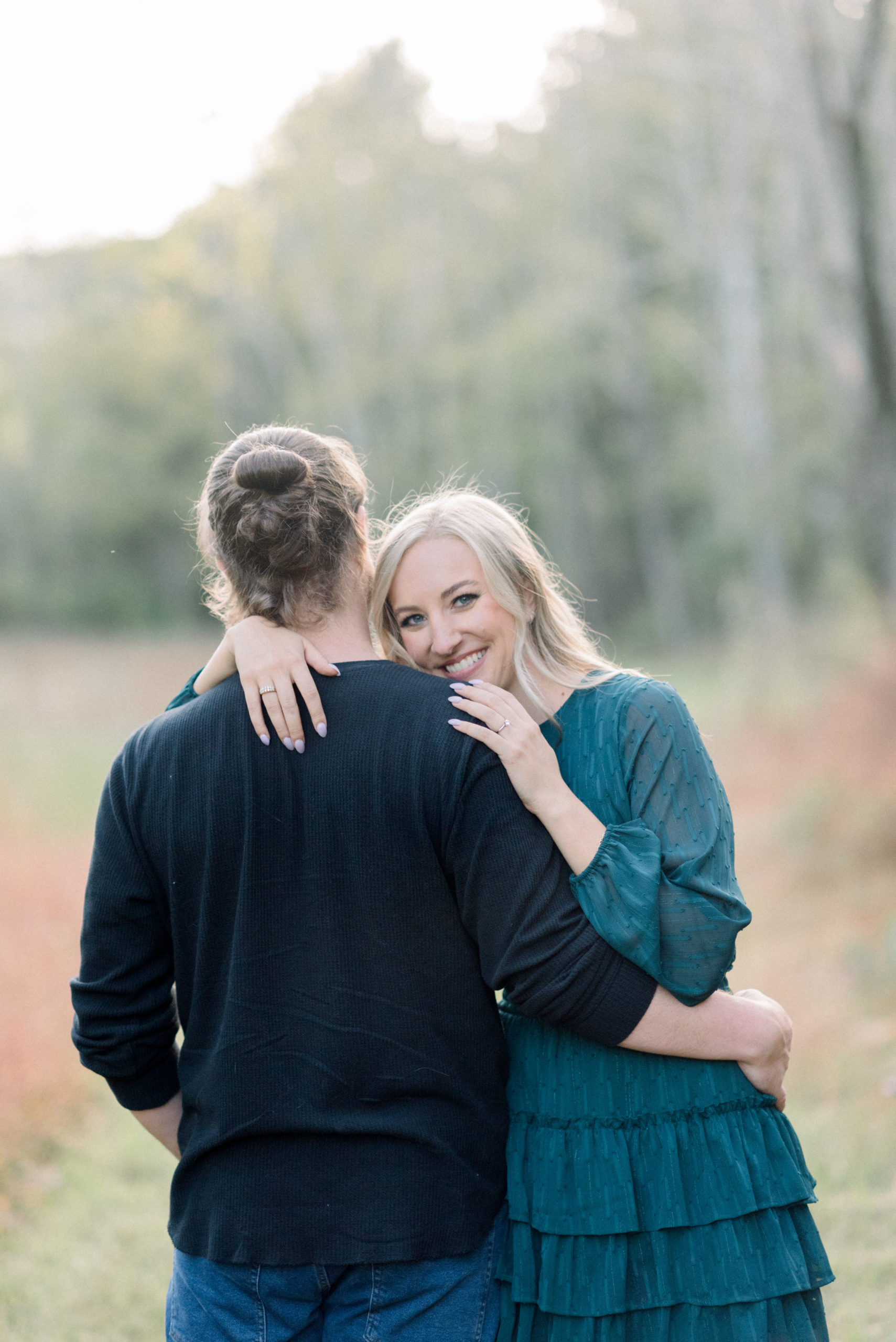 woman hugging man looking over shoulder and smiling