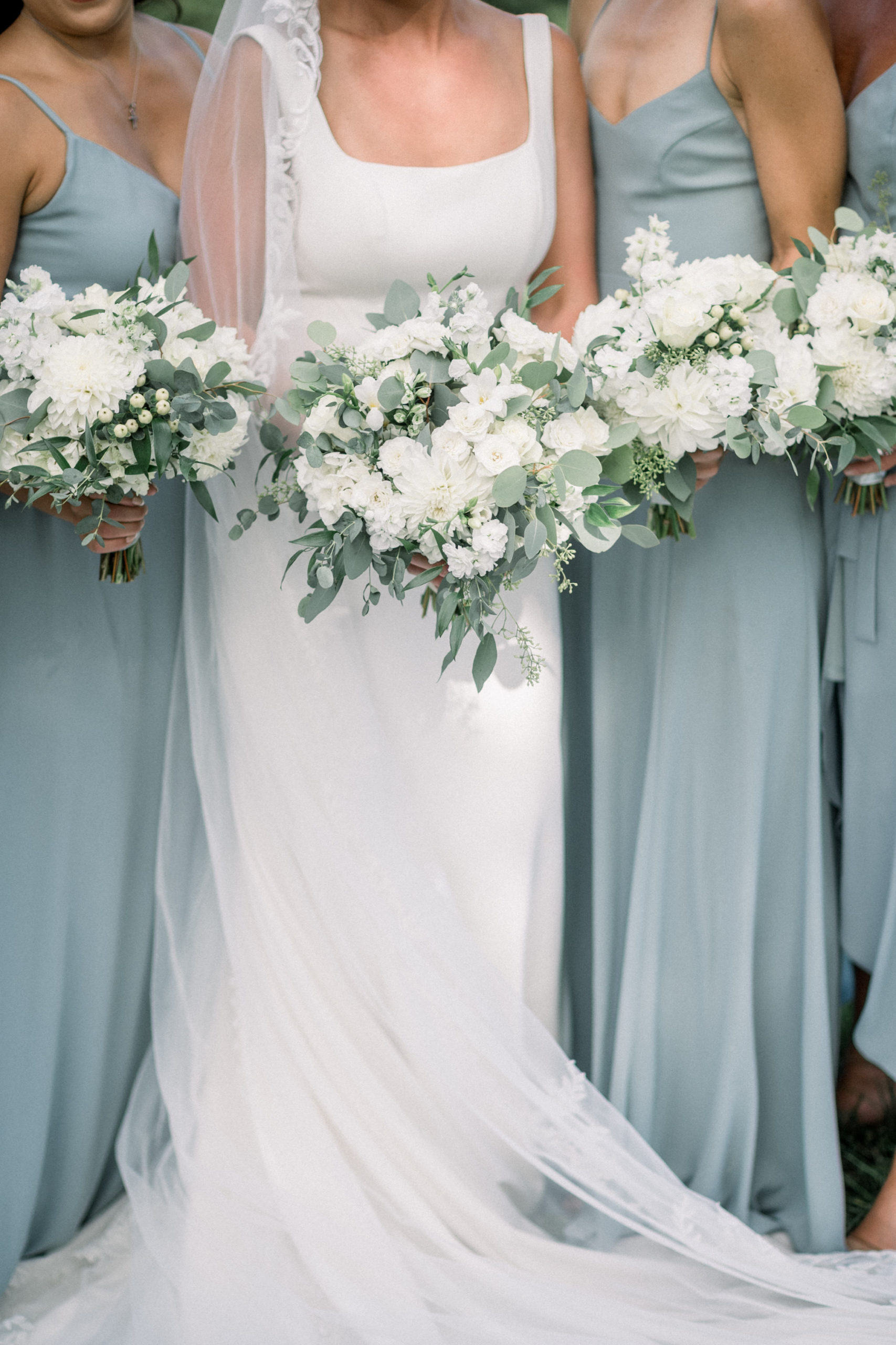 detail shot of bride and bridesmaids wedding bouquets with light teal blue bridesmaids dresses