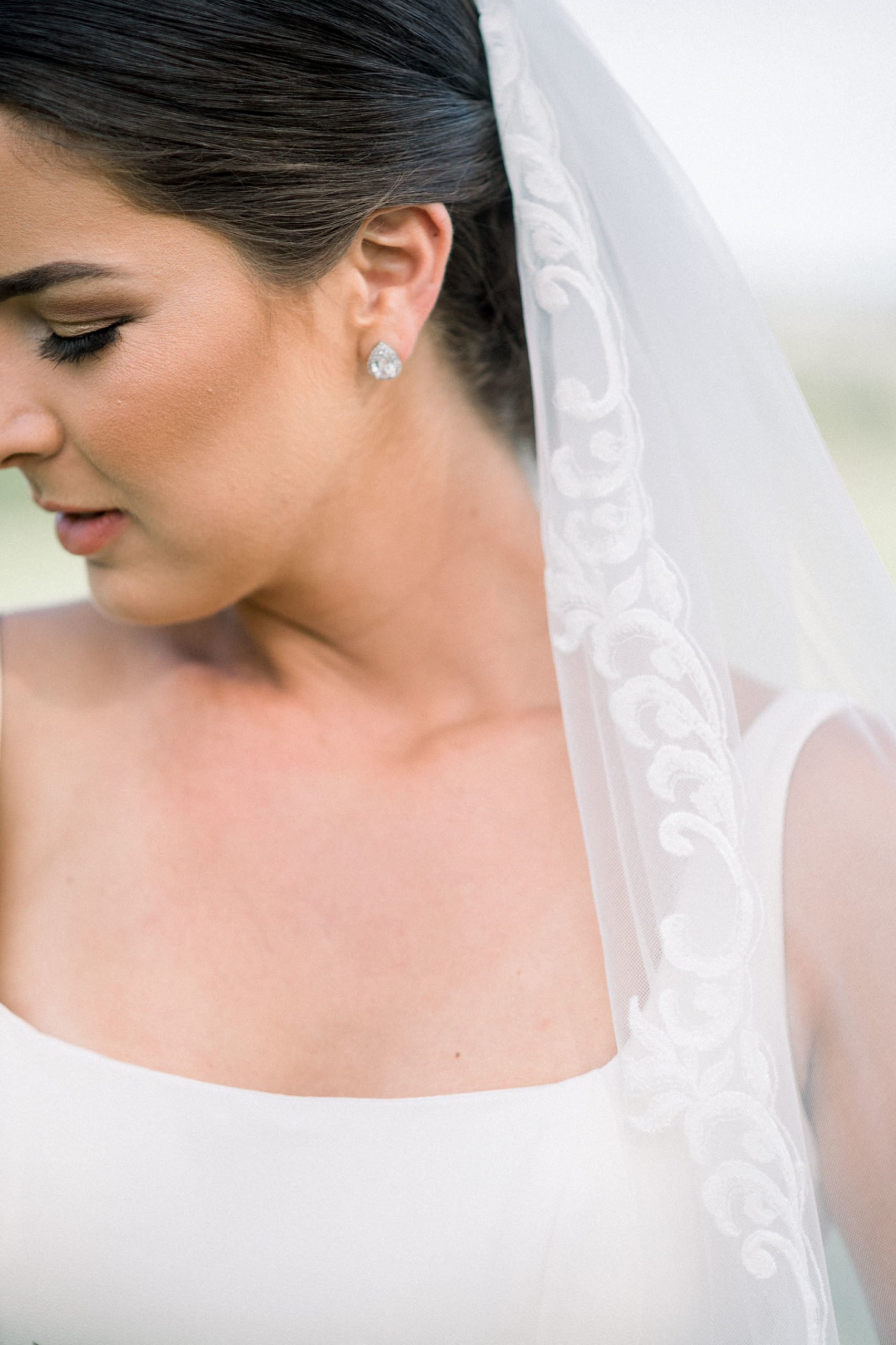 detail shot of brides wedding veil that she wear right above her low bun bridal hairstyle