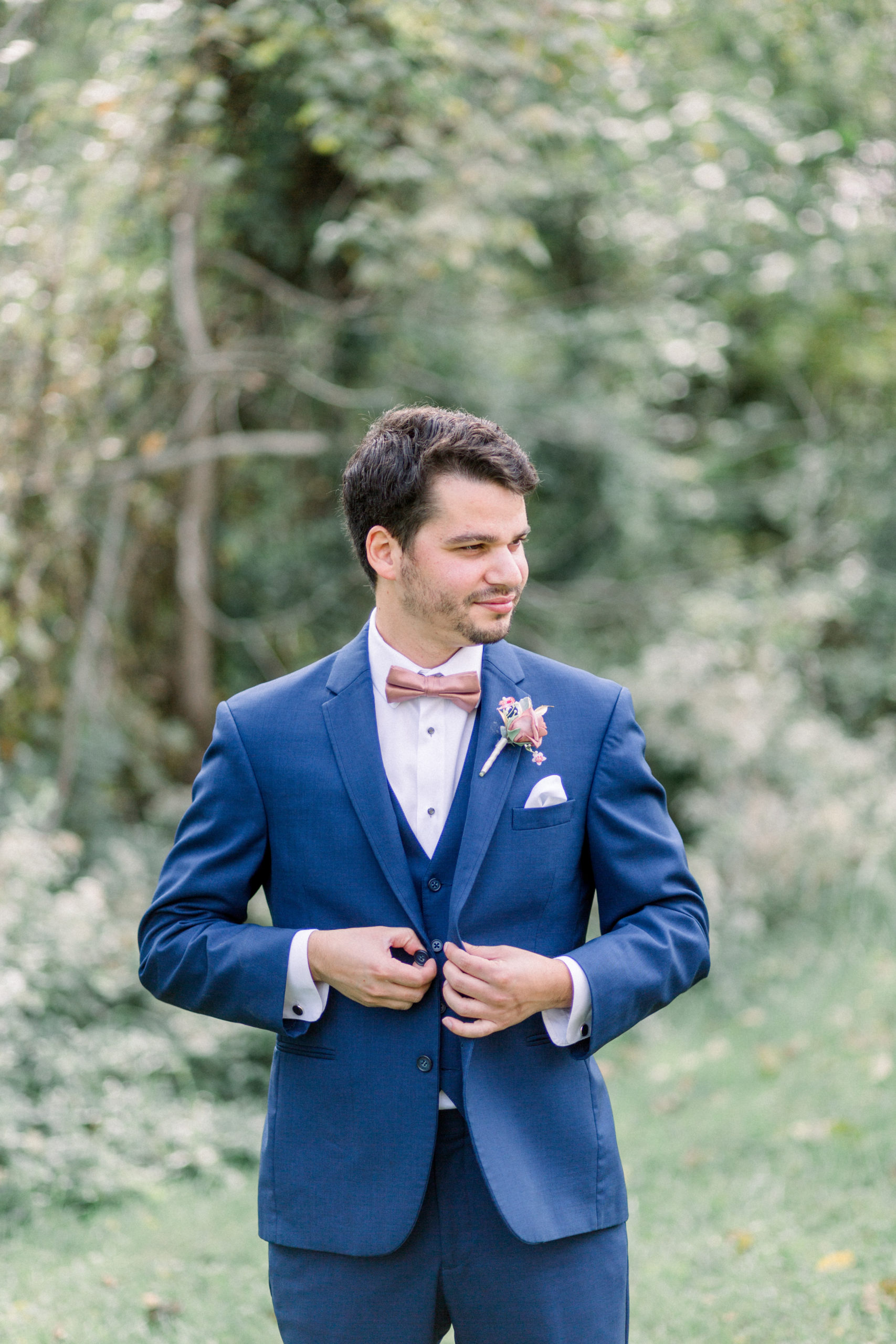 groom fastening buttons on jacket