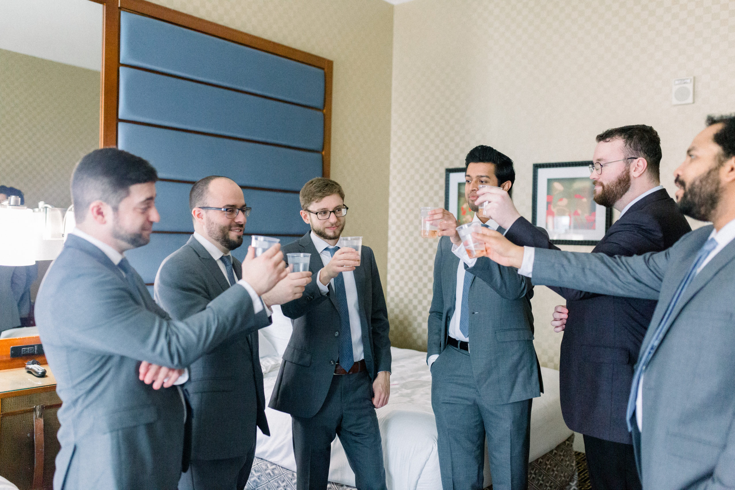 groom toasting beverages with groomsmen