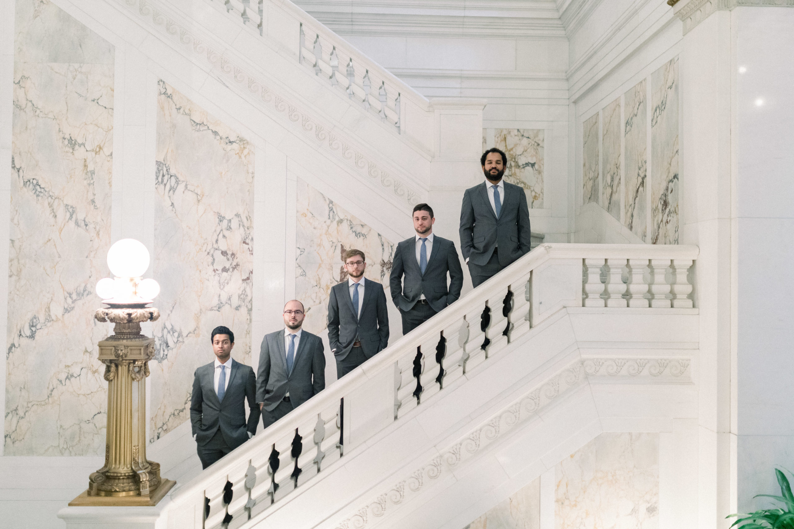 groomsmen standing on stairs with hands in pockets