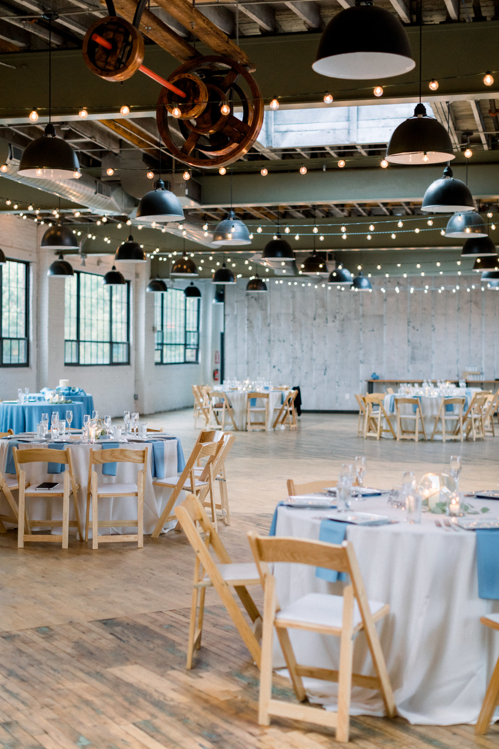 wedding reception overview with wooden tables and white tablecloths
