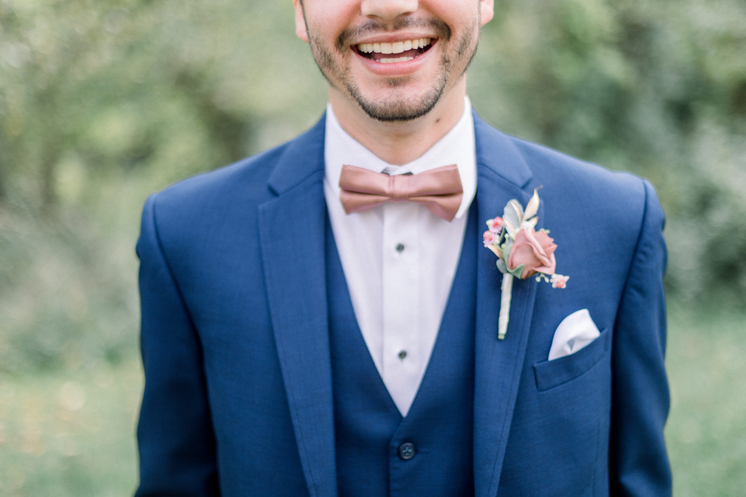 close up of groom's attire and his smile