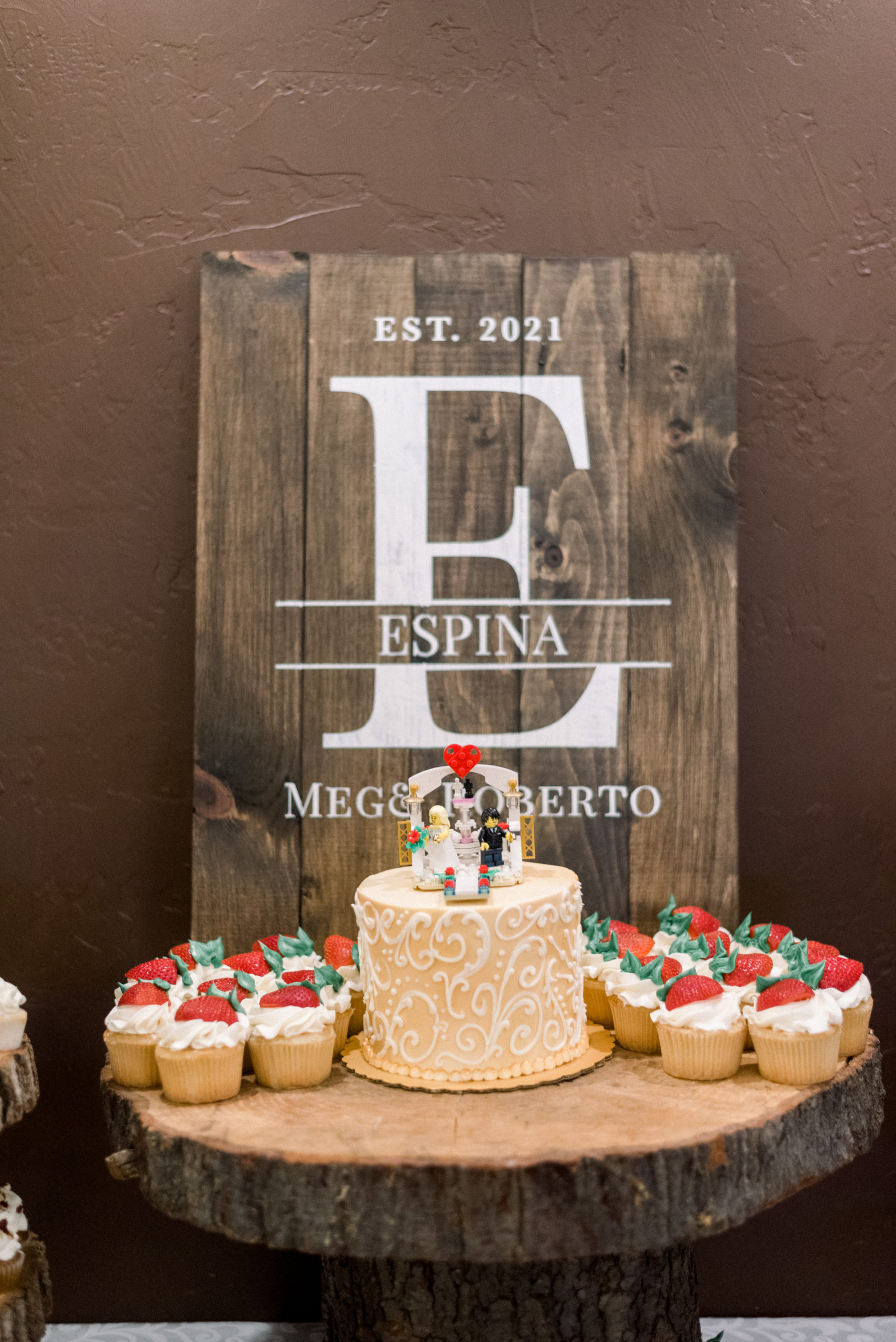 wooden sign beside wedding cake with lego bride and groom on top