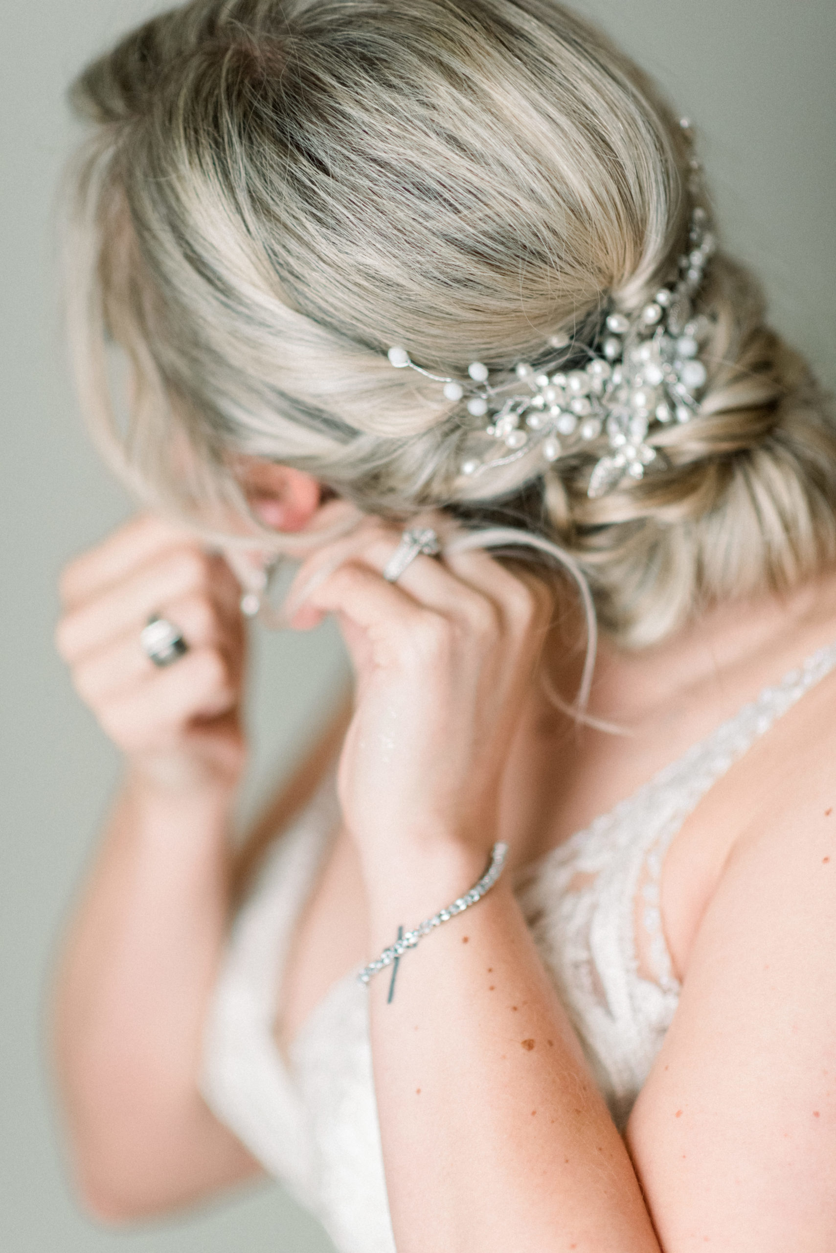bride putting on earrings before wedding ceremony