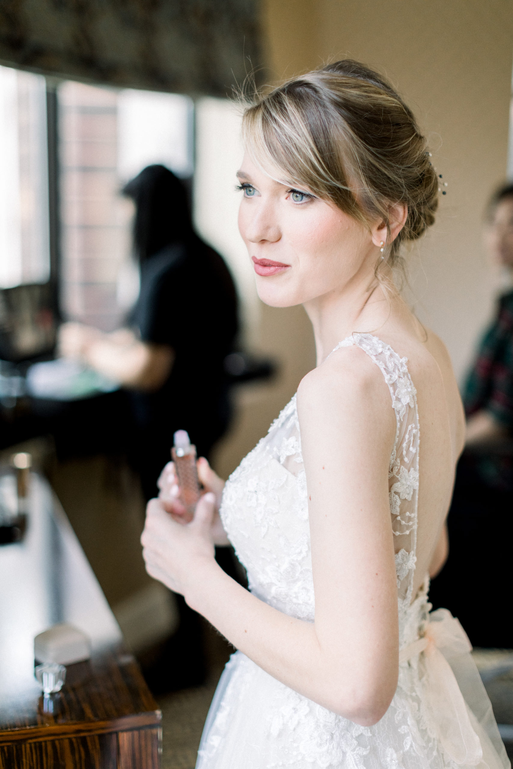 bride holding perfume during portraits
