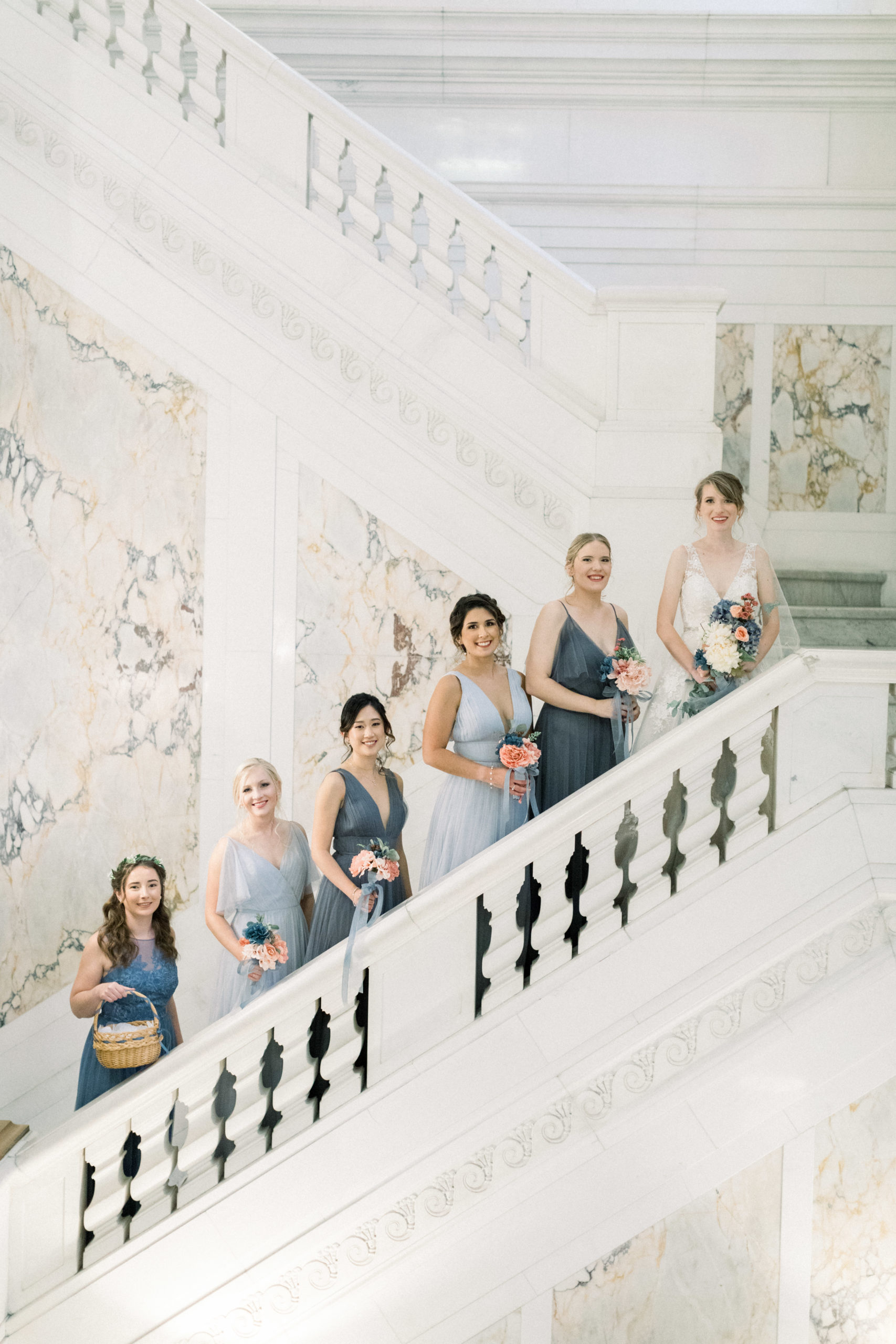bridesmaids standing on stairs in varying shades of blue