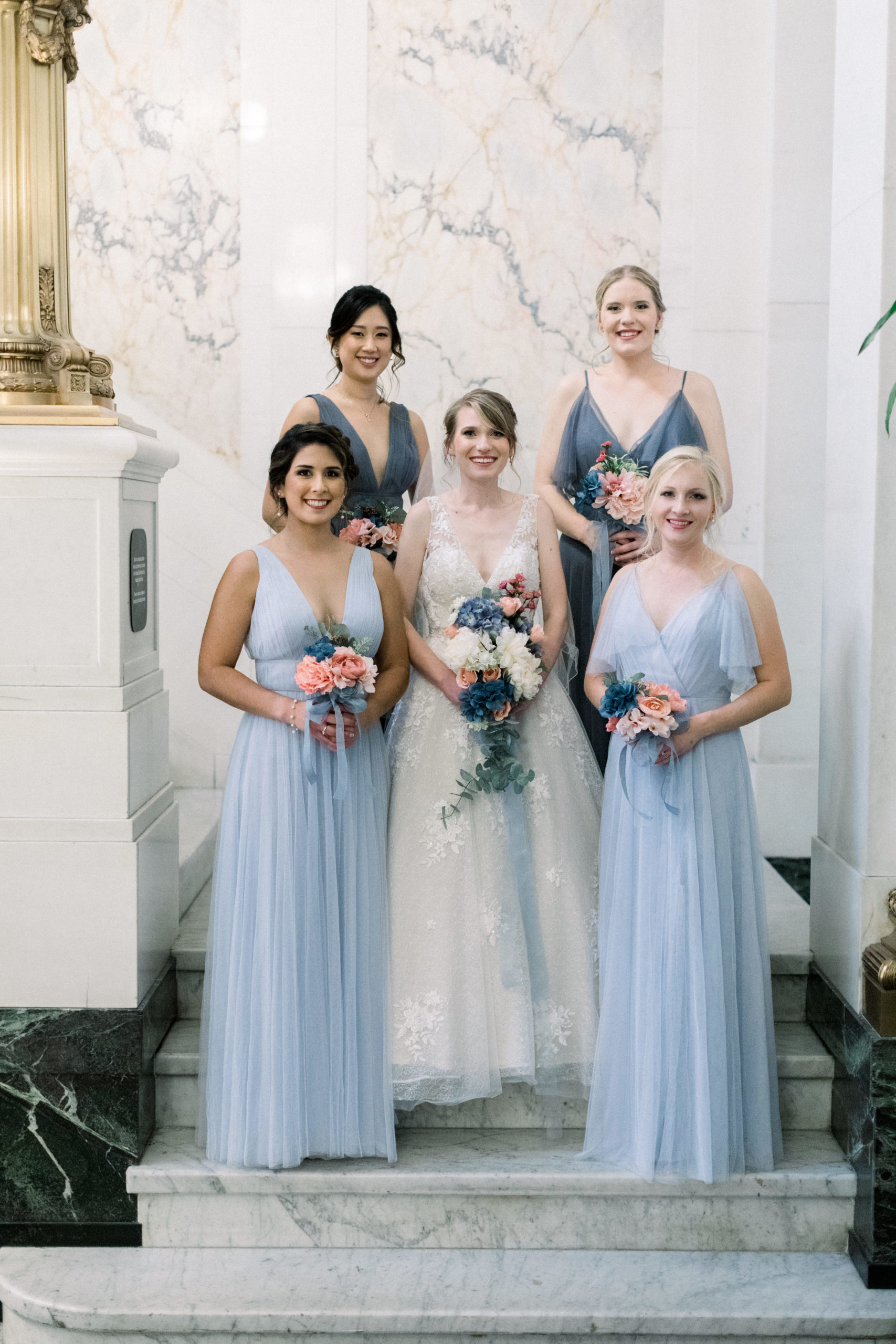 bride standing with bridesmaids holding bouquets