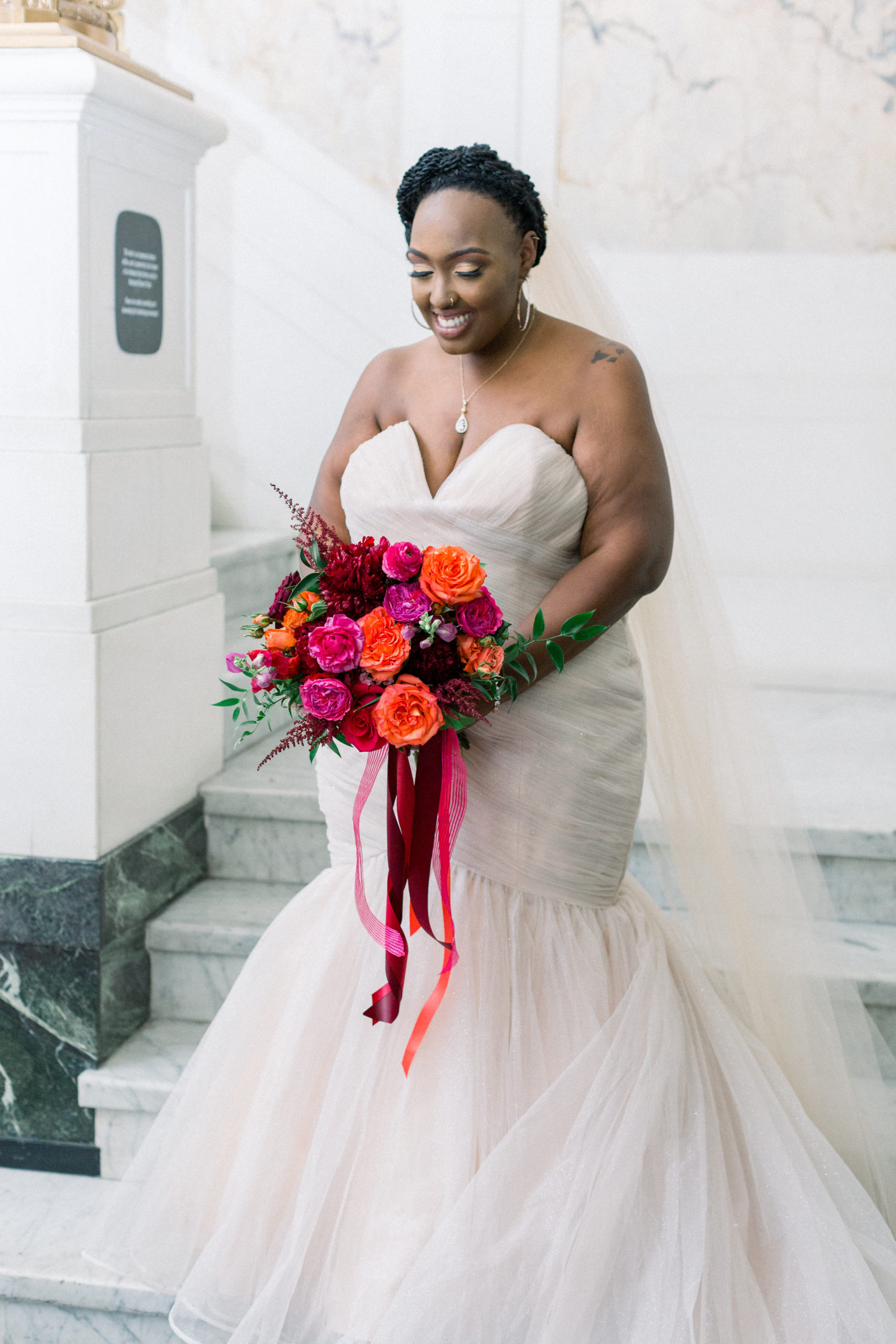 bride holding colorful red, pink and orange bouquet before Romantic Fall Baltimore Wedding