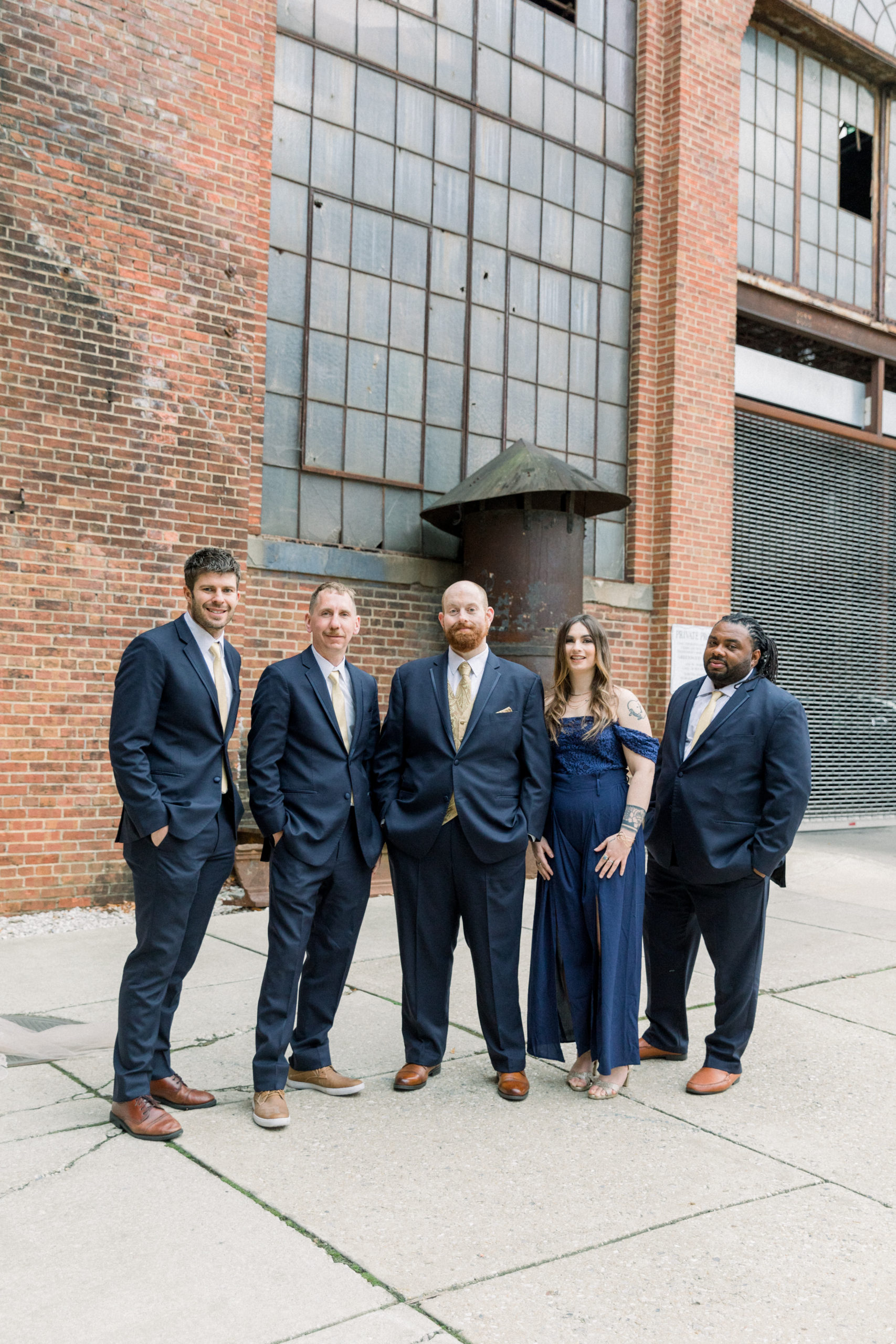 groom standing with wedding party wearing navy suits after Romantic Fall Baltimore Wedding
