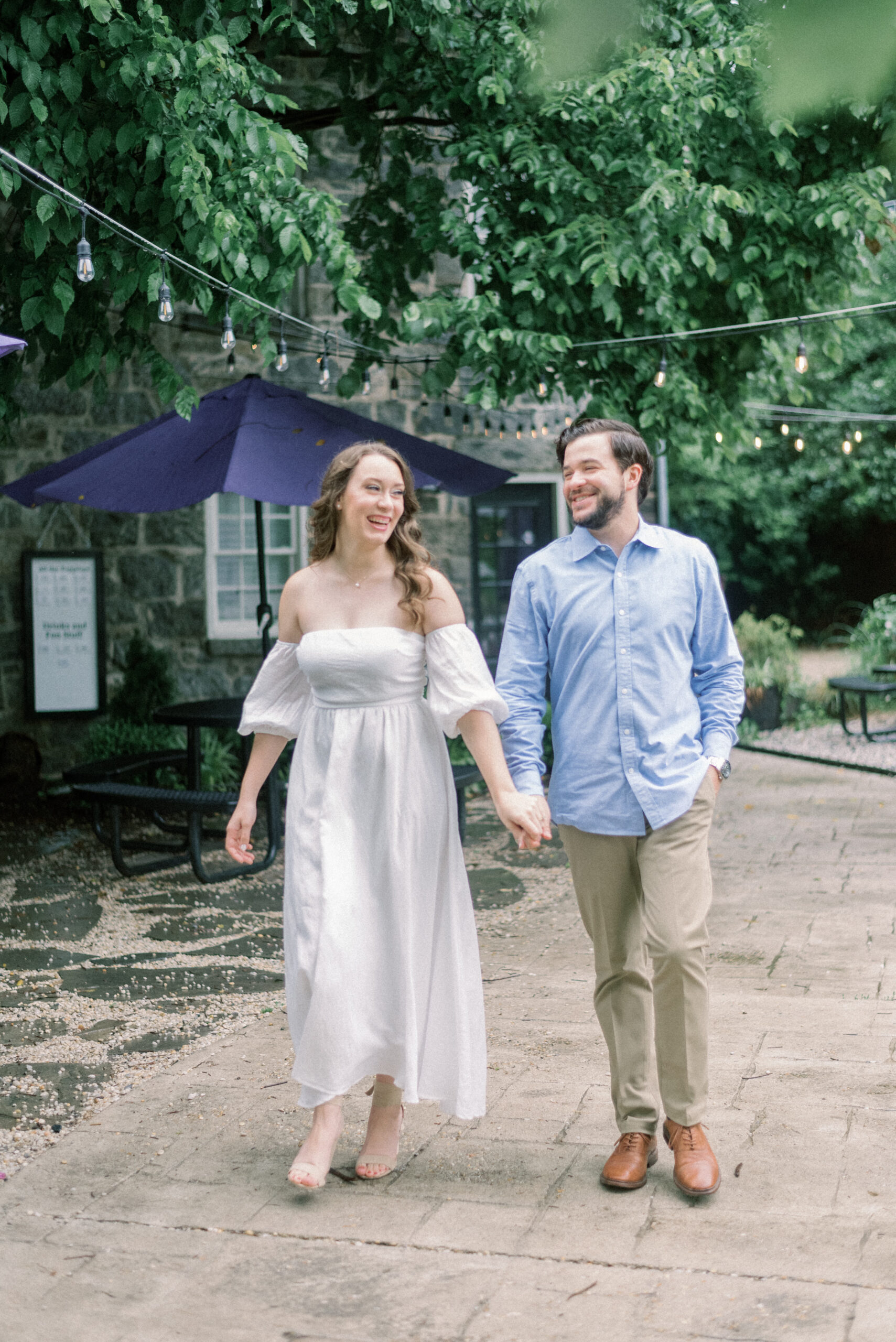 Maryland wedding photographer captures man and woman walking hand in hand in Old Ellicott City engagement photos