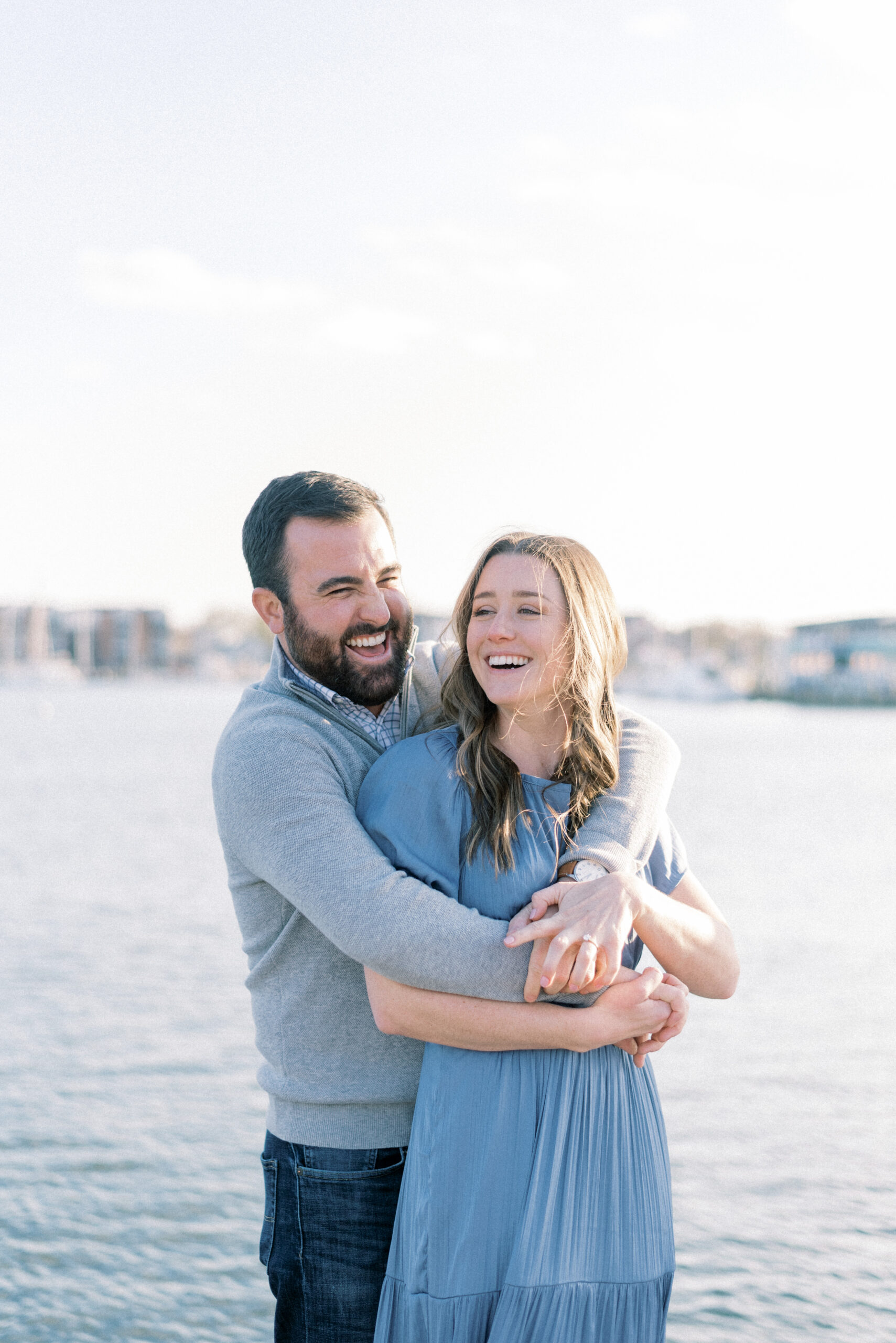 Maryland wedding photographer captures man and woman embracing and laughing during Sunset Downtown Annapolis Engagement Portraits