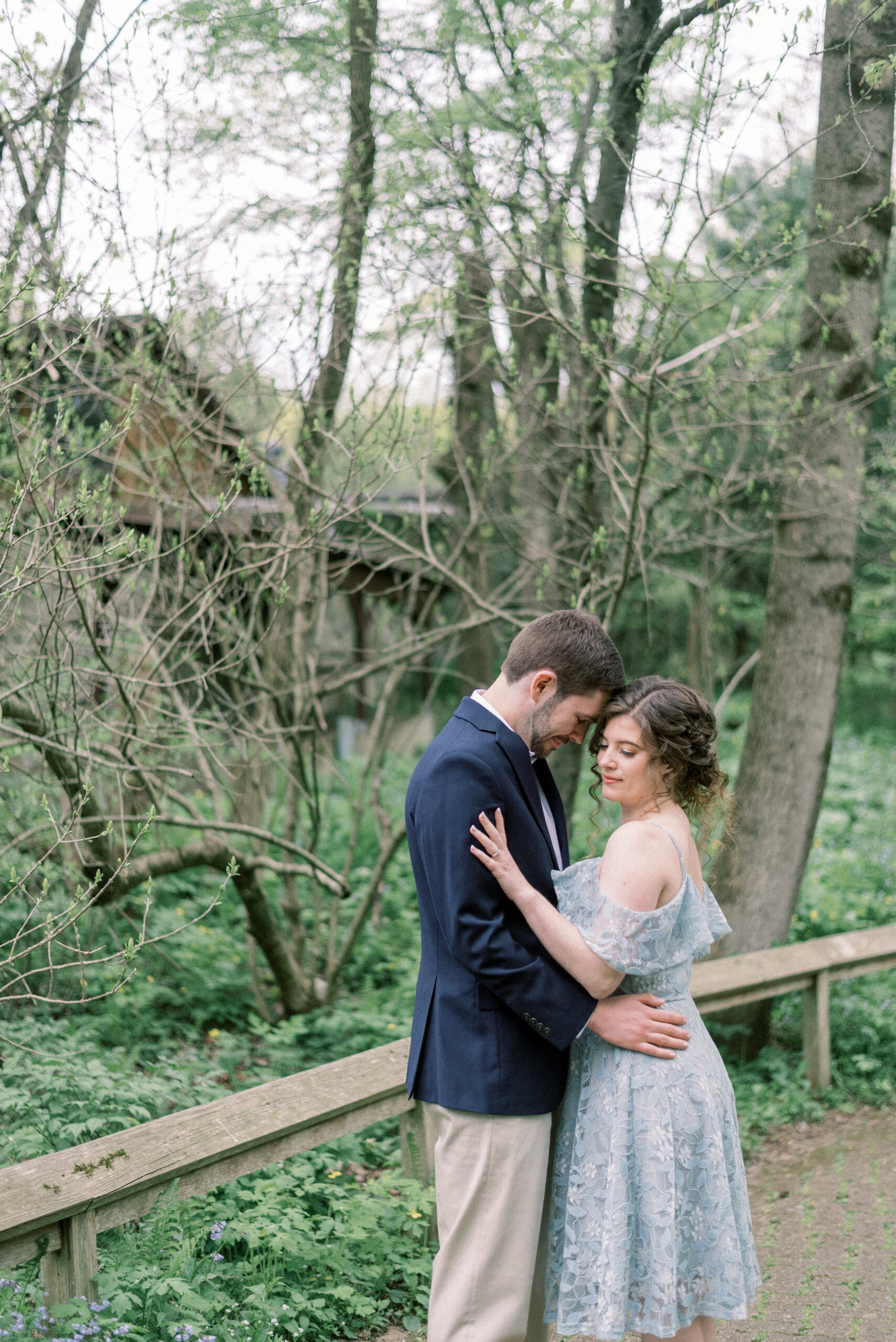Maryland wedding photographer captures newly engaged couple hugging in forest