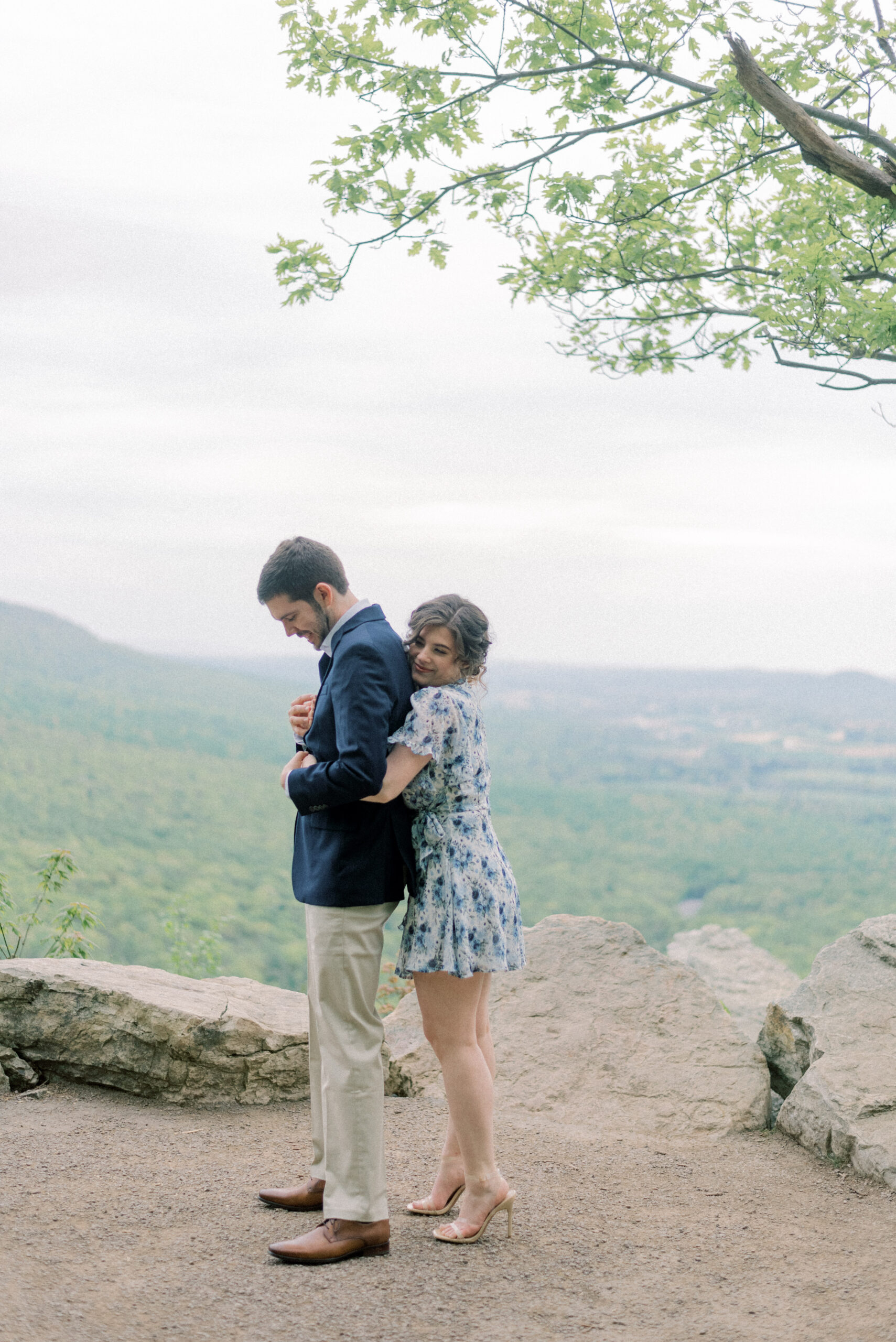 Maryland wedding photographer captures woman hugging man from behind at Hawk Mountain engagement portraits