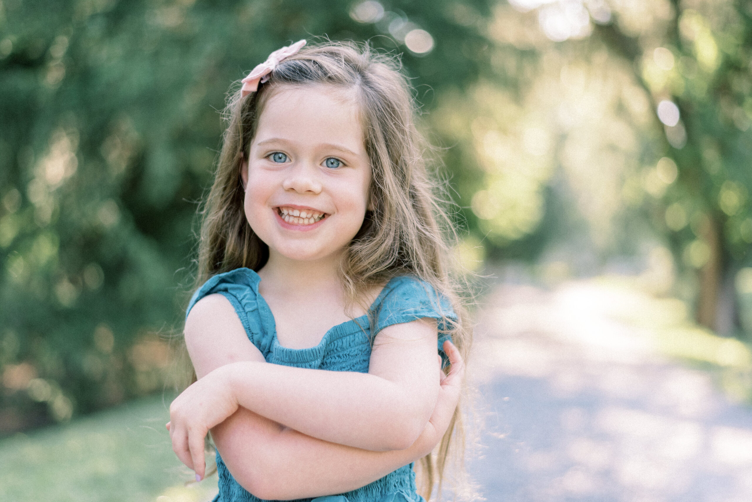 Maryland photographer captures young girl with long brunette hair smiling wearing blue dress