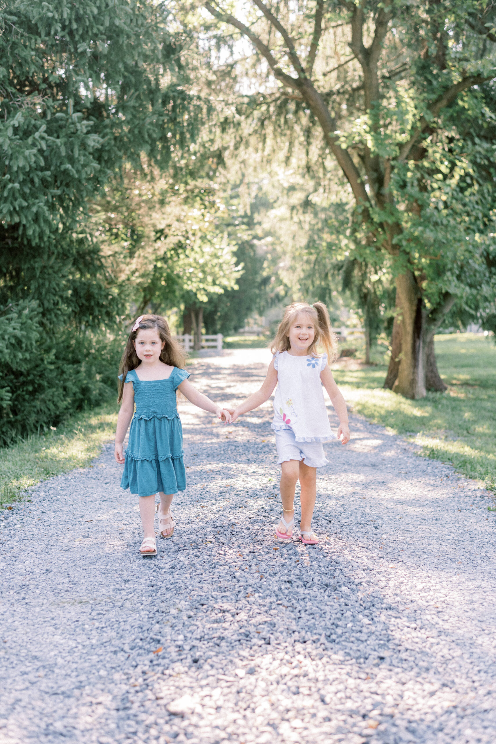 Maryland photographer captures two girls holding hands walking during Fall Howard County extended family portraits