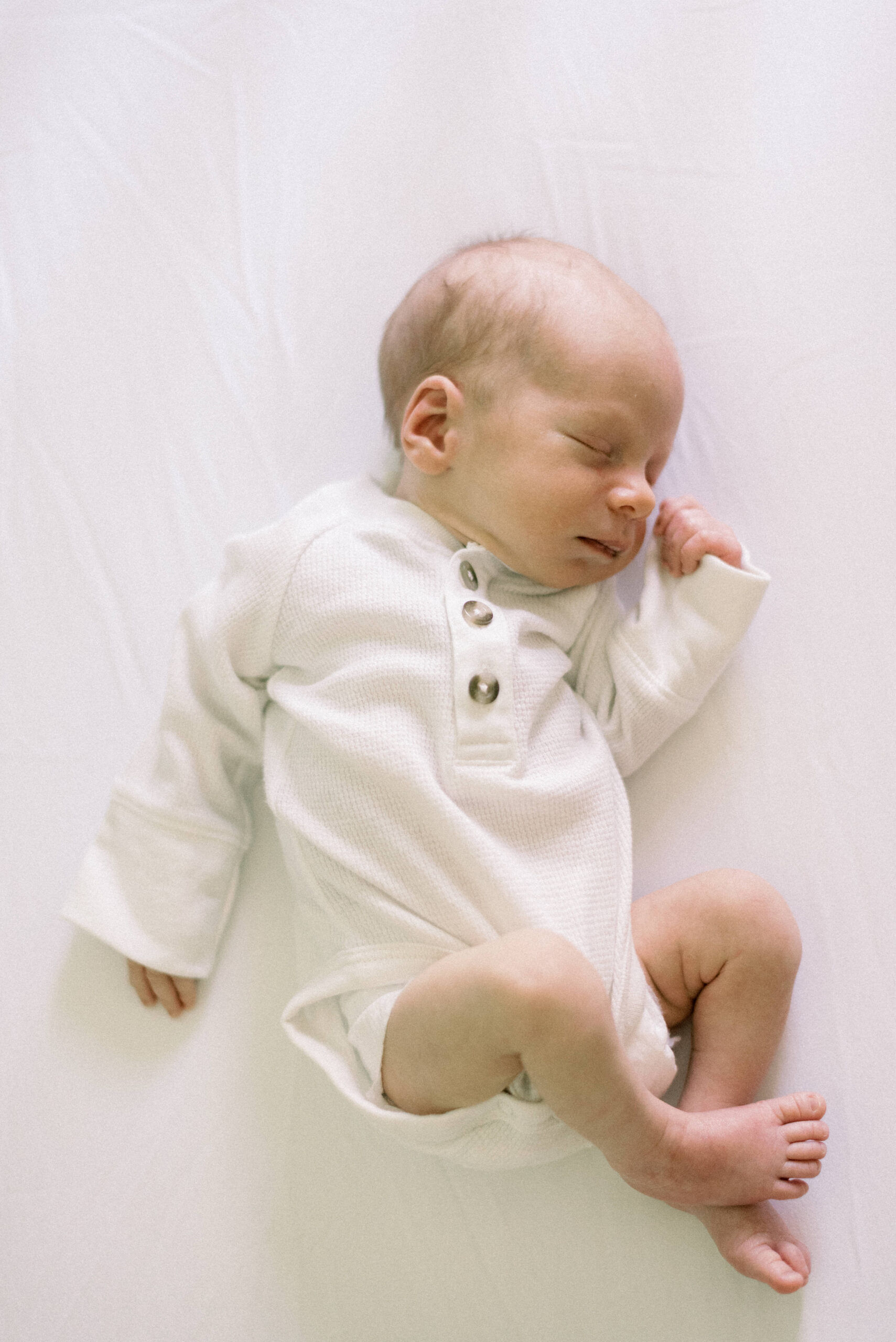 Pennsylvania photographer captures baby lying on white sheet sleeping