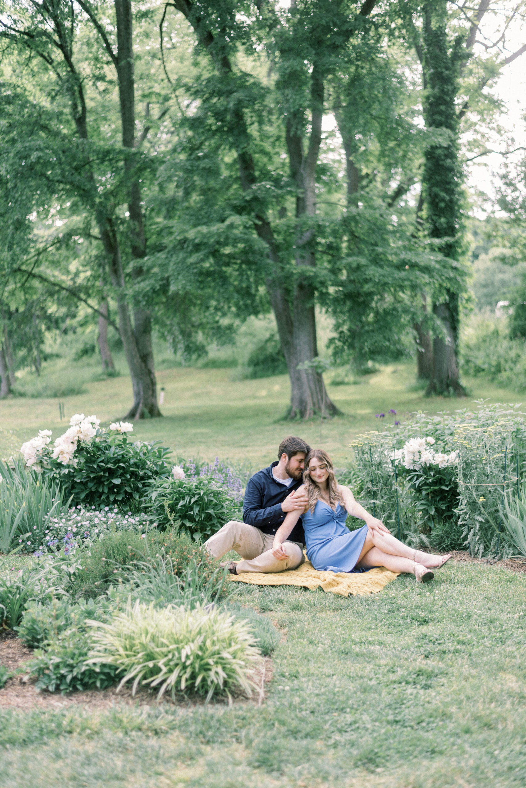 Maryland wedding photographer captures couple sitting on picnic blanket during engagement portraits