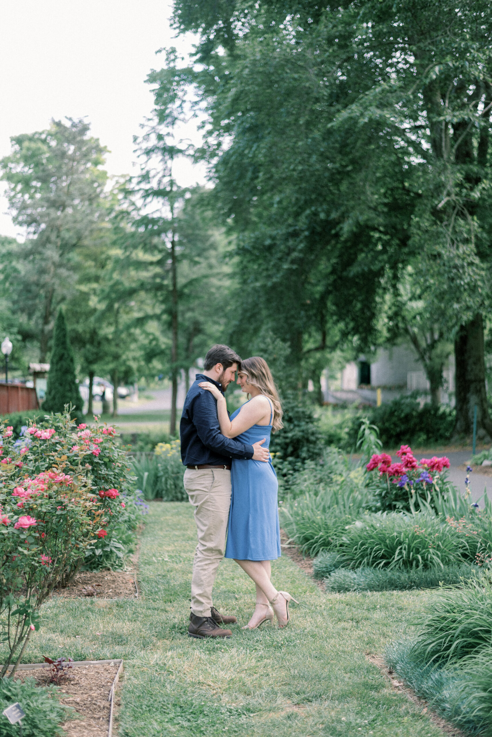 Maryland wedding photographer captures man and woman embracing in gardens during engagement portraits