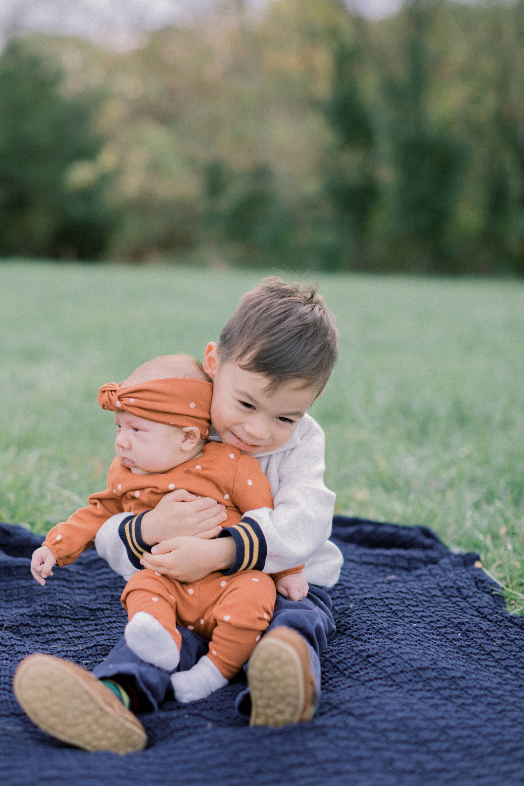 Maryland photographer captures young boy holding sister on picnic blanket