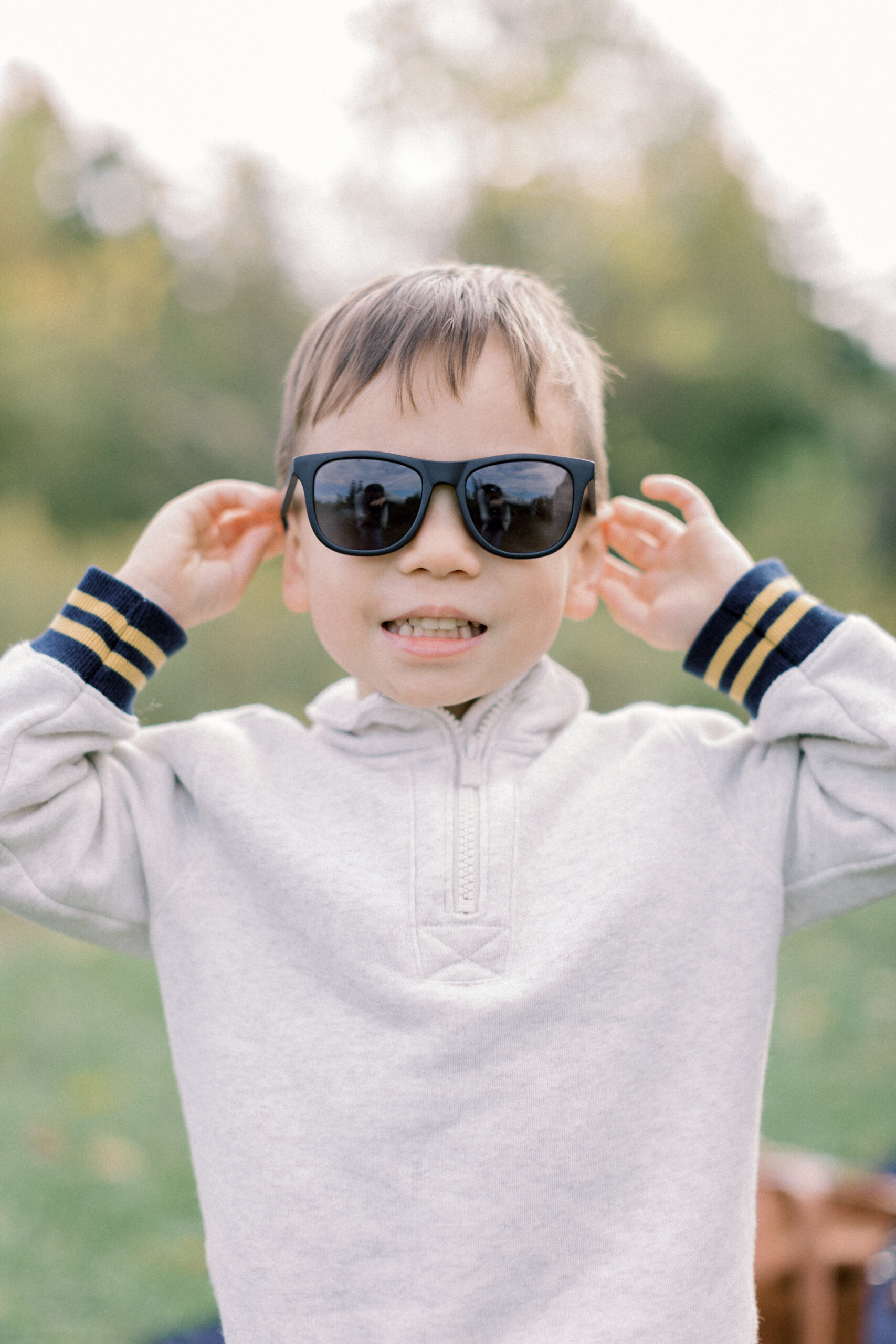 Maryland photographer captures child wearing sunglasses and smiling during family portraits at Howard Conservancy