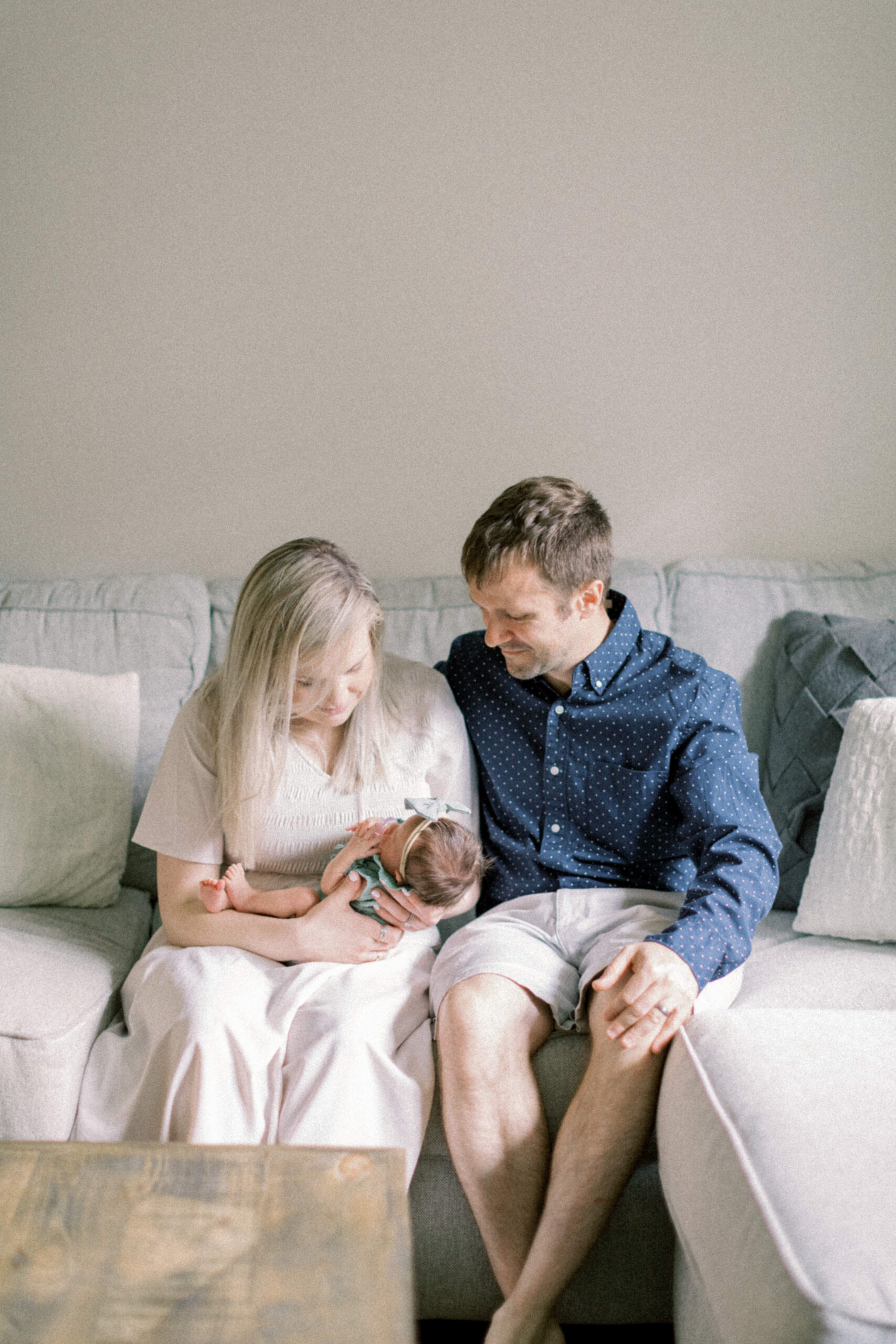 Maryland photographer captures mother holding baby and sitting with husband on couch