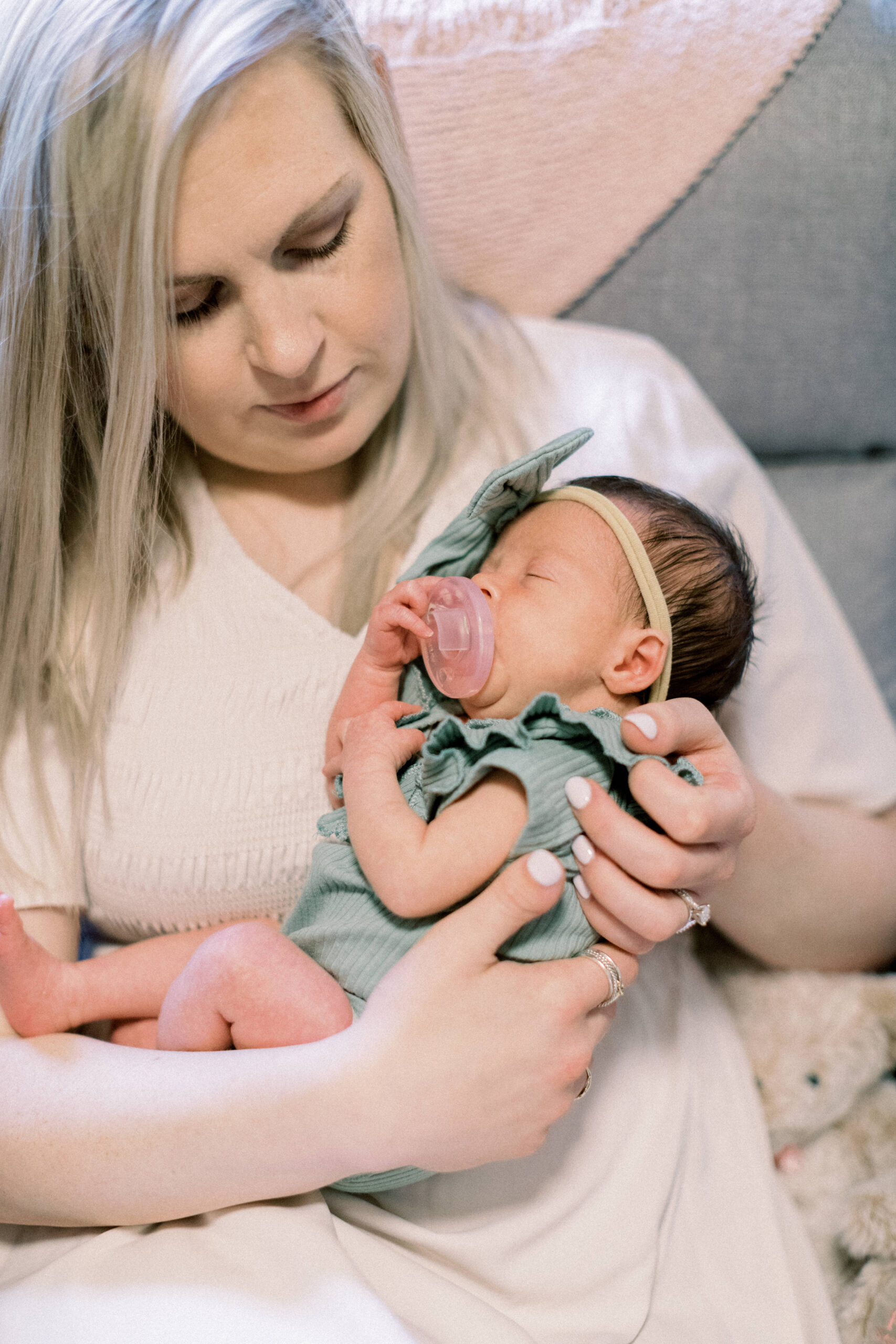 Maryland photographer captures mother holding baby during at home newborn portraits
