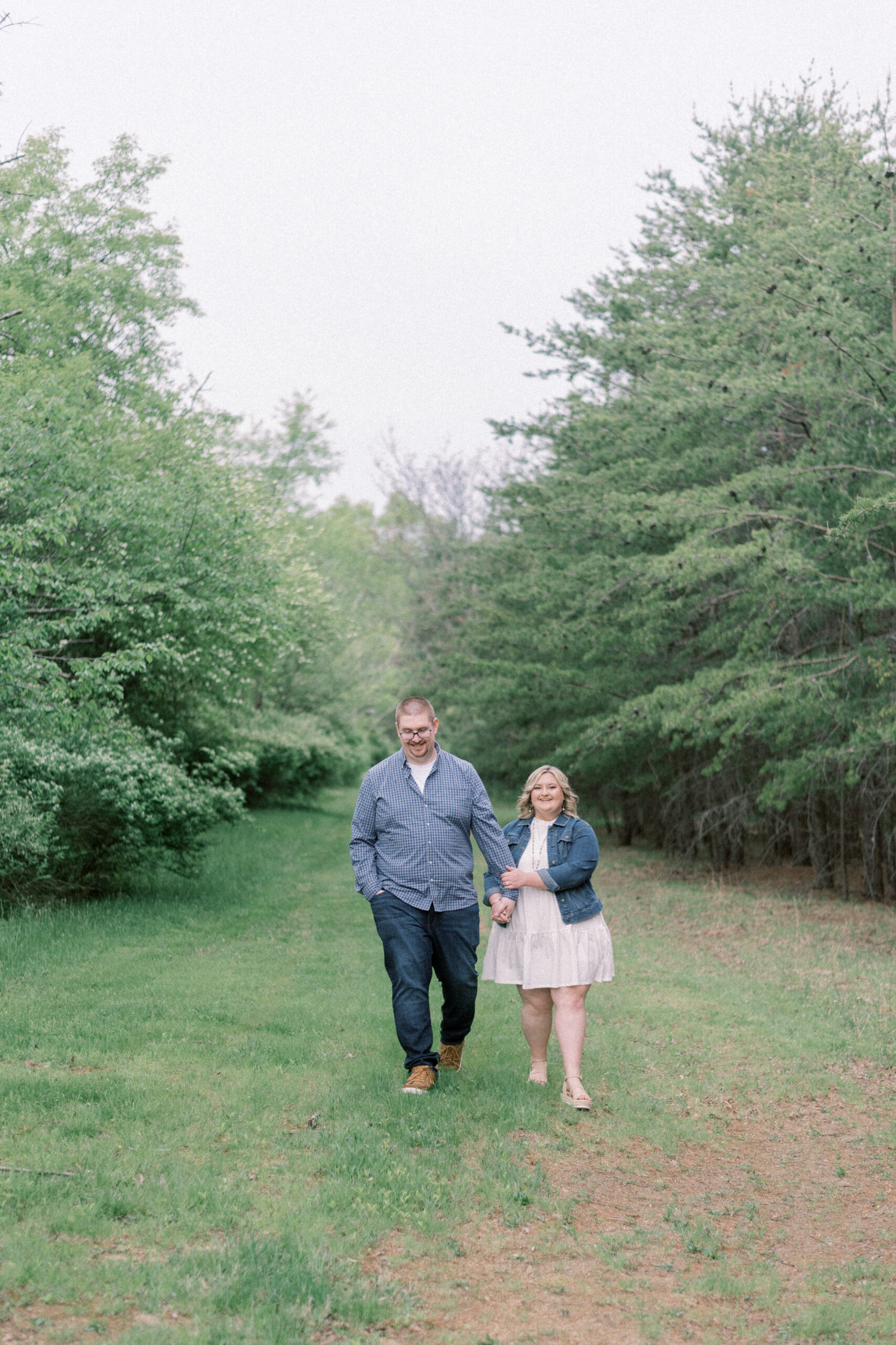 Pennsylvania wedding photographer captures couple walking hand in hand during spring engagement portraits