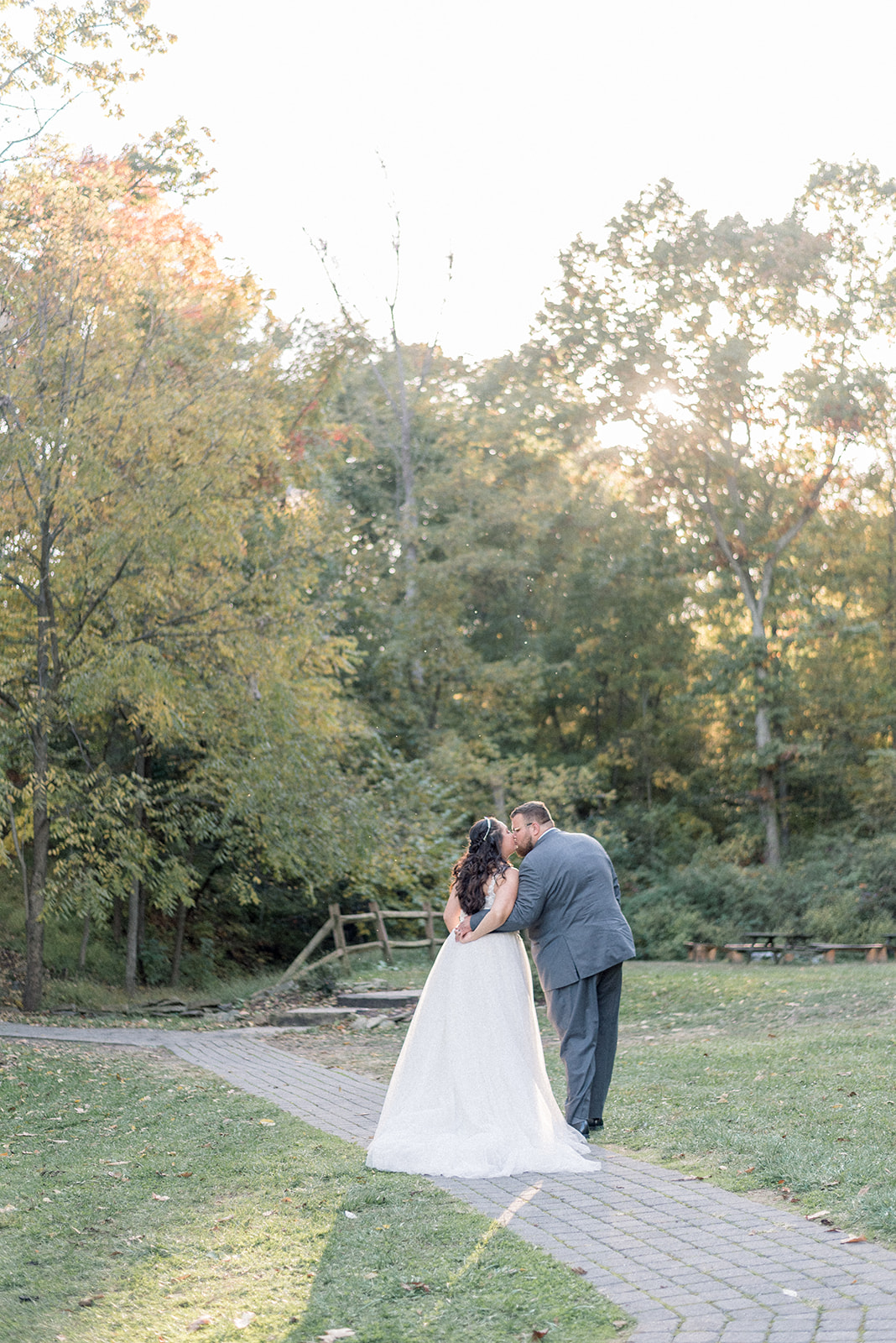 Pennsylvania wedding photographer captures bride and groom kissing while walking together outdoors