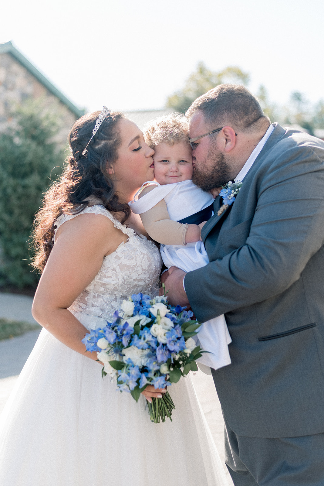 Pennsylvania wedding photographer captures bride and groom kissing baby's cheeks