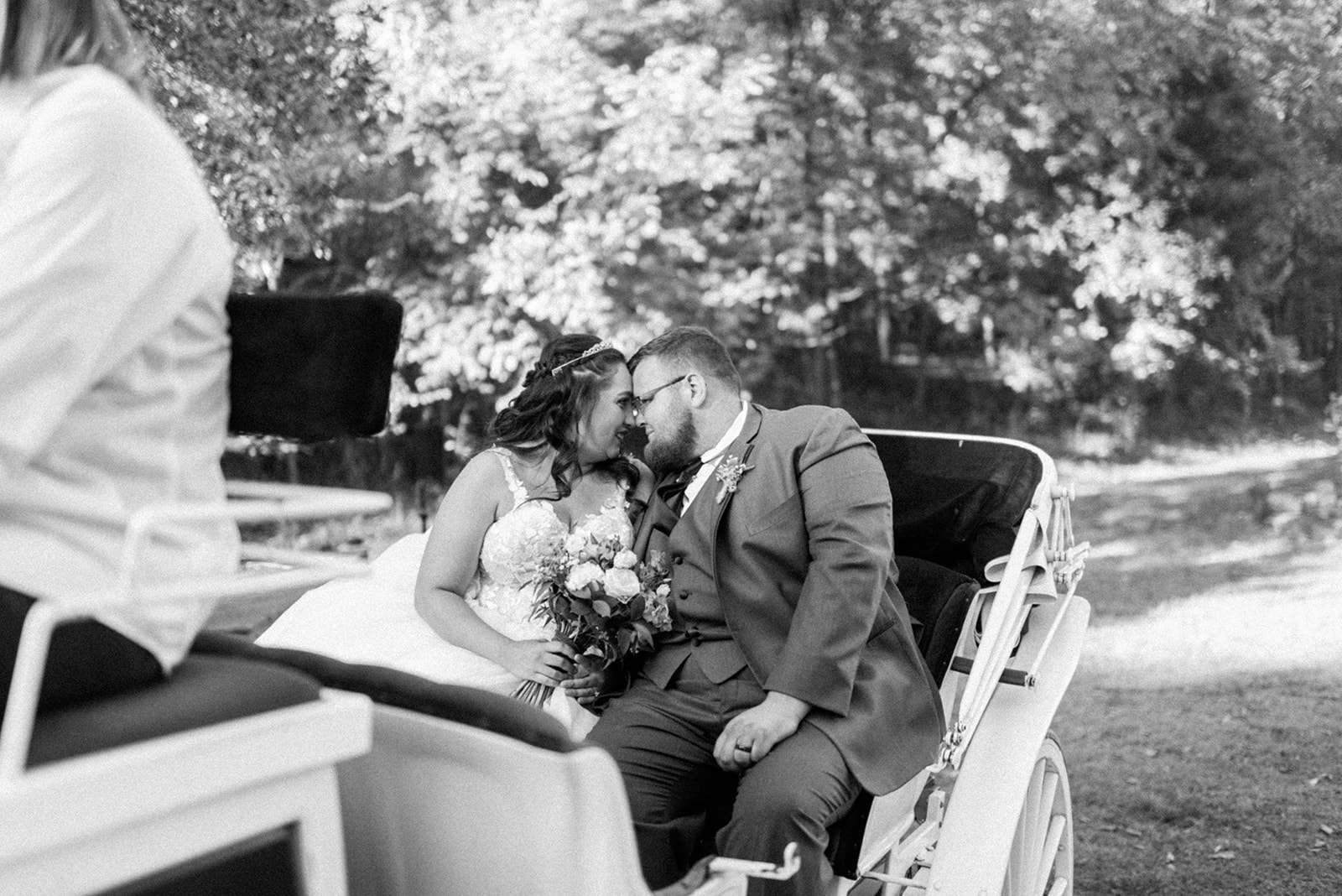 Pennsylvania wedding photographer captures black and white portrait of bride and groom on horse-drawn carriage