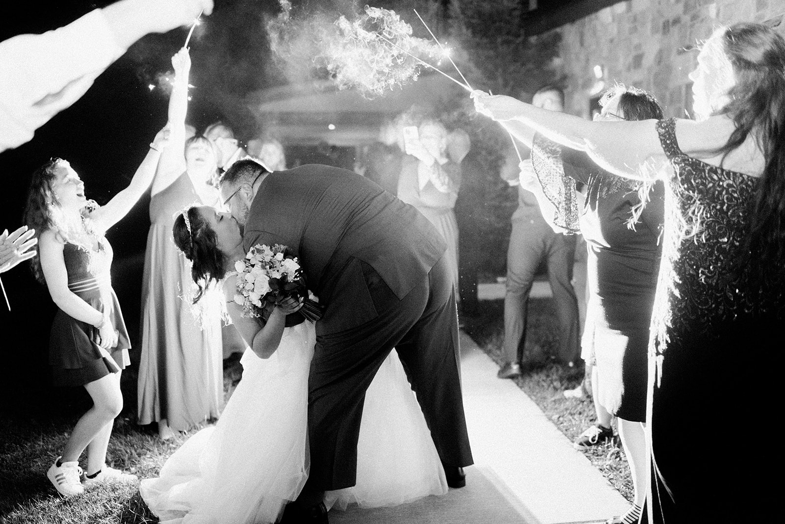 Pennsylvania wedding photographer captures bride and groom dip kiss during sparkler exit