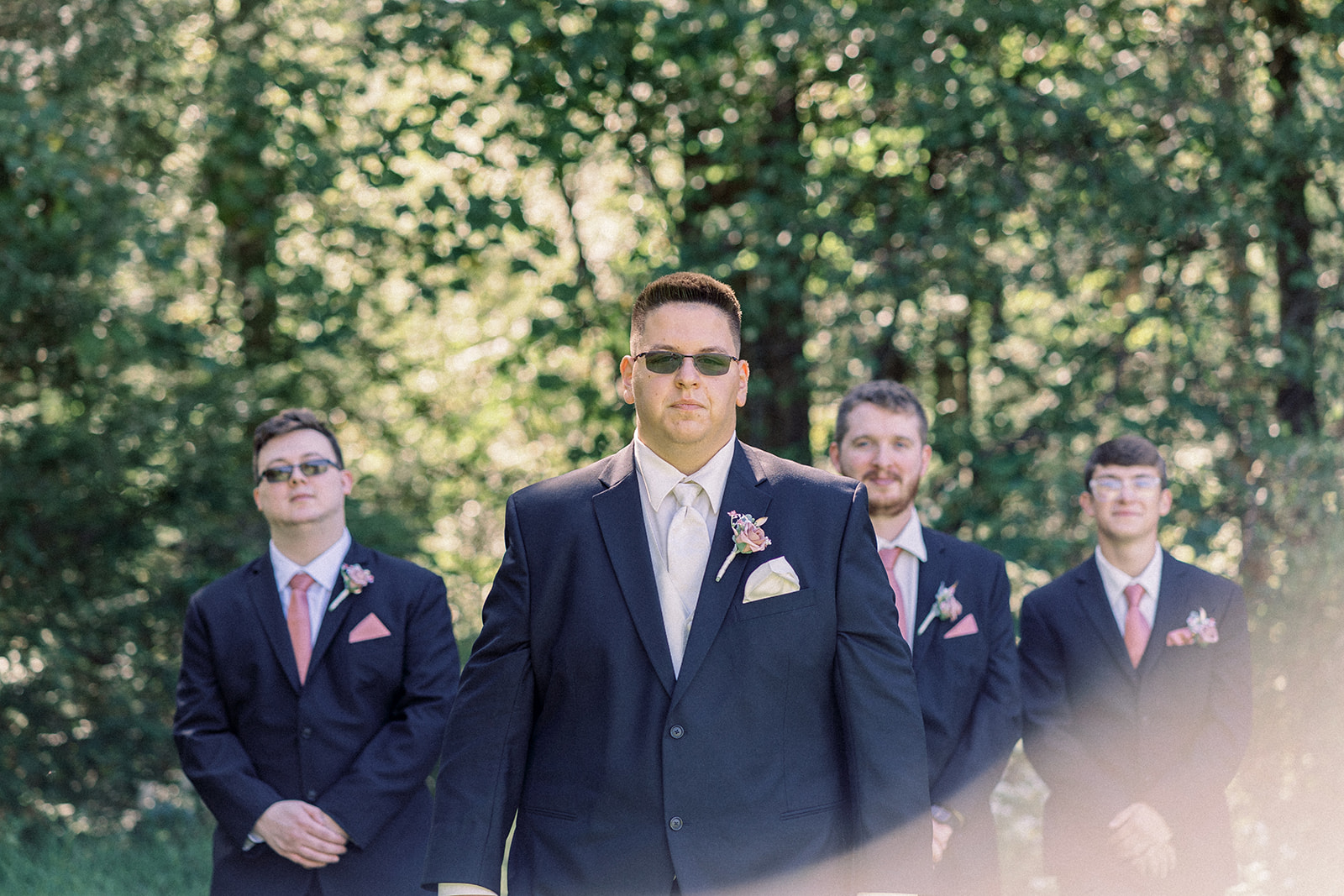 Pennsylvania wedding photographer captures groom walking with groomsmen behind him wearing navy suit