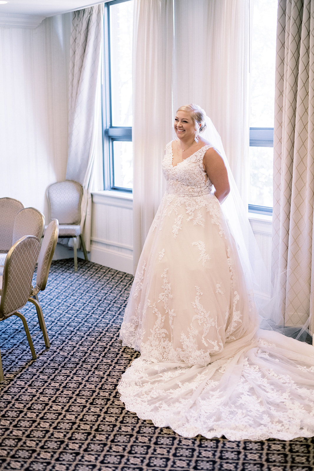 Pennsylvania wedding photographer captures bride smiling with hands behind back in wedding dress