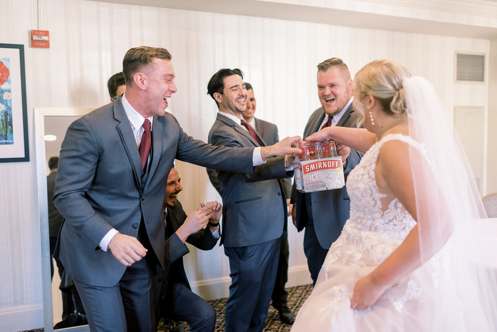 Pennsylvania wedding photographer captures bride handing groomsmen 6-pack