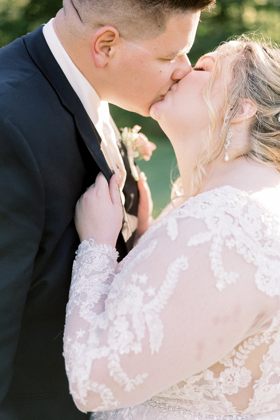 Pennsylvania wedding photographer captures bride holding groom's jacket kissing him