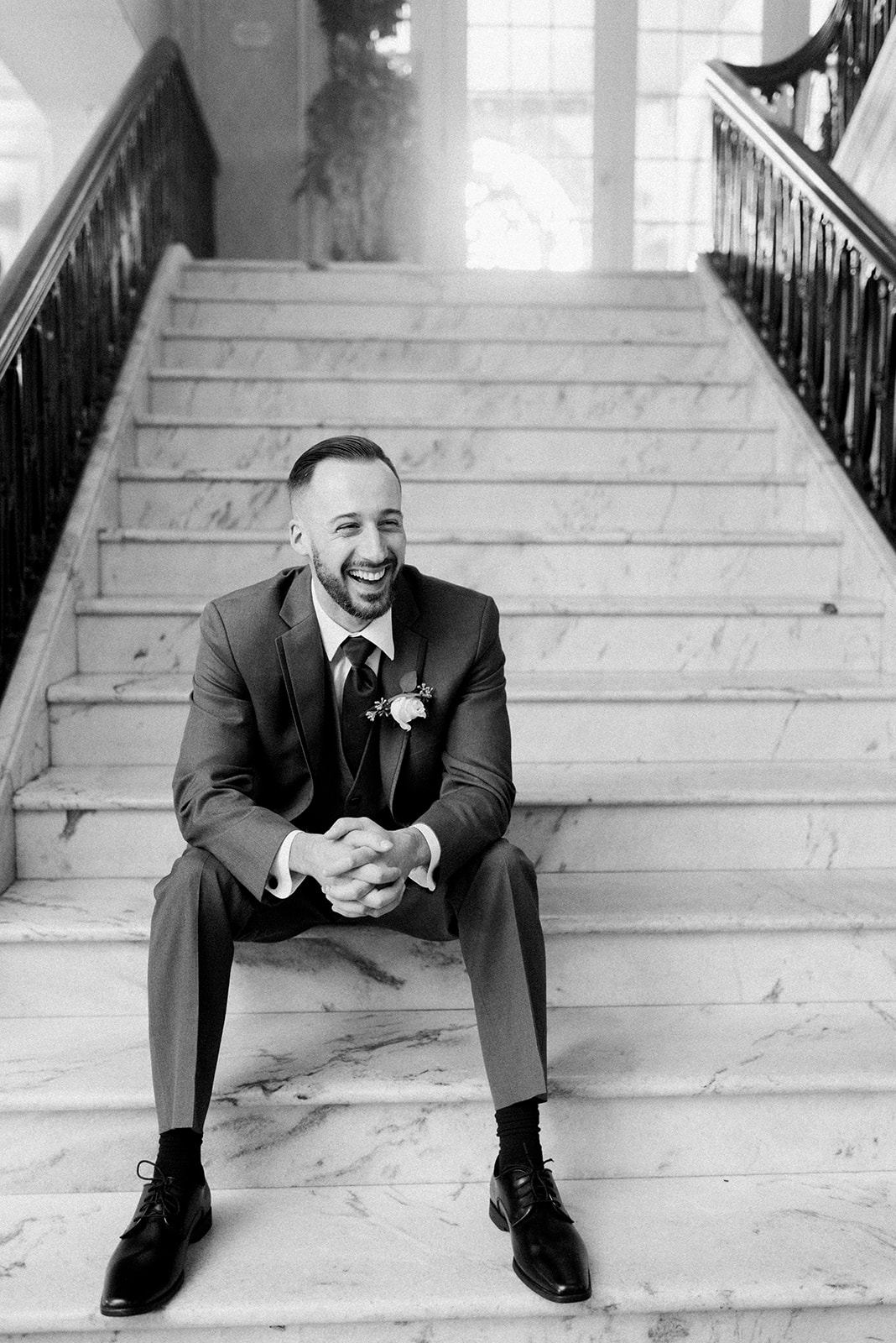Pennsylvania wedding photographer captures groom sitting on stairs laughing