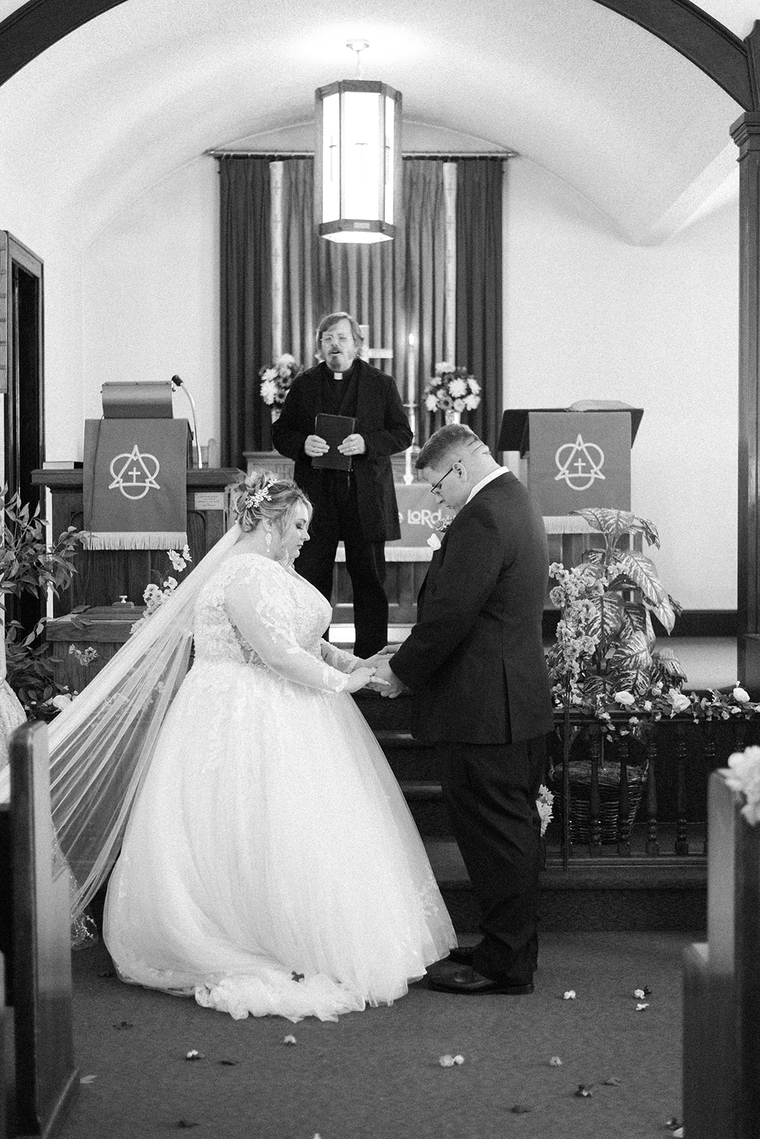 Pennsylvania wedding photographer captures bride and groom bowing heads at alter before wedding ceremony