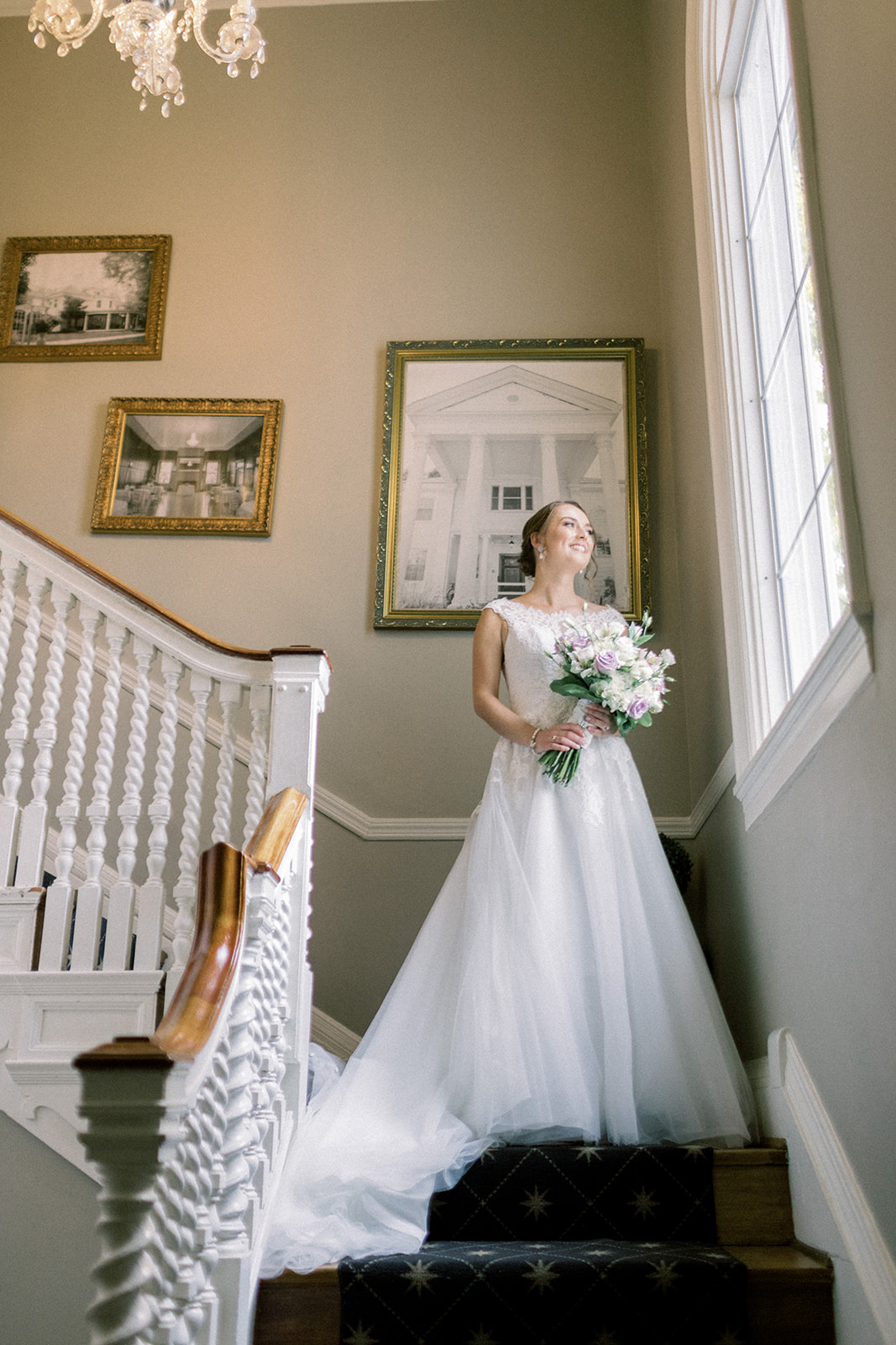 Pennsylvania wedding photographer captures bride walking down the stairs holding bouquet