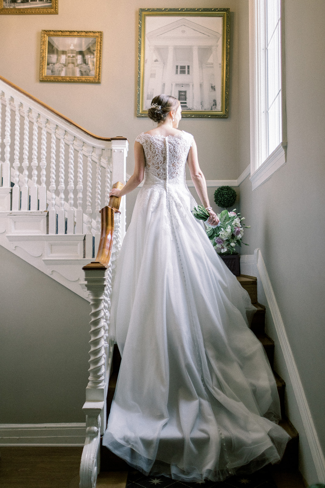 Pennsylvania wedding photographer captures bride walking up stairs with long train