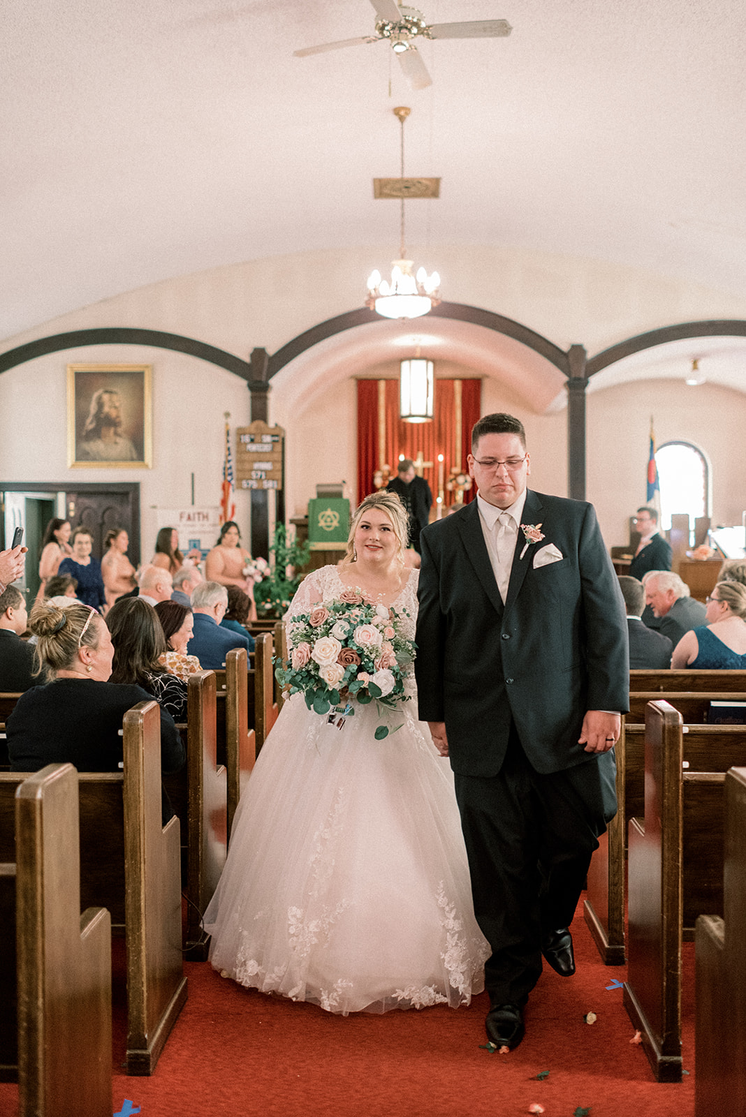 Pennsylvania wedding photographer captures bride and groom walking out of church as newly married husband and wife