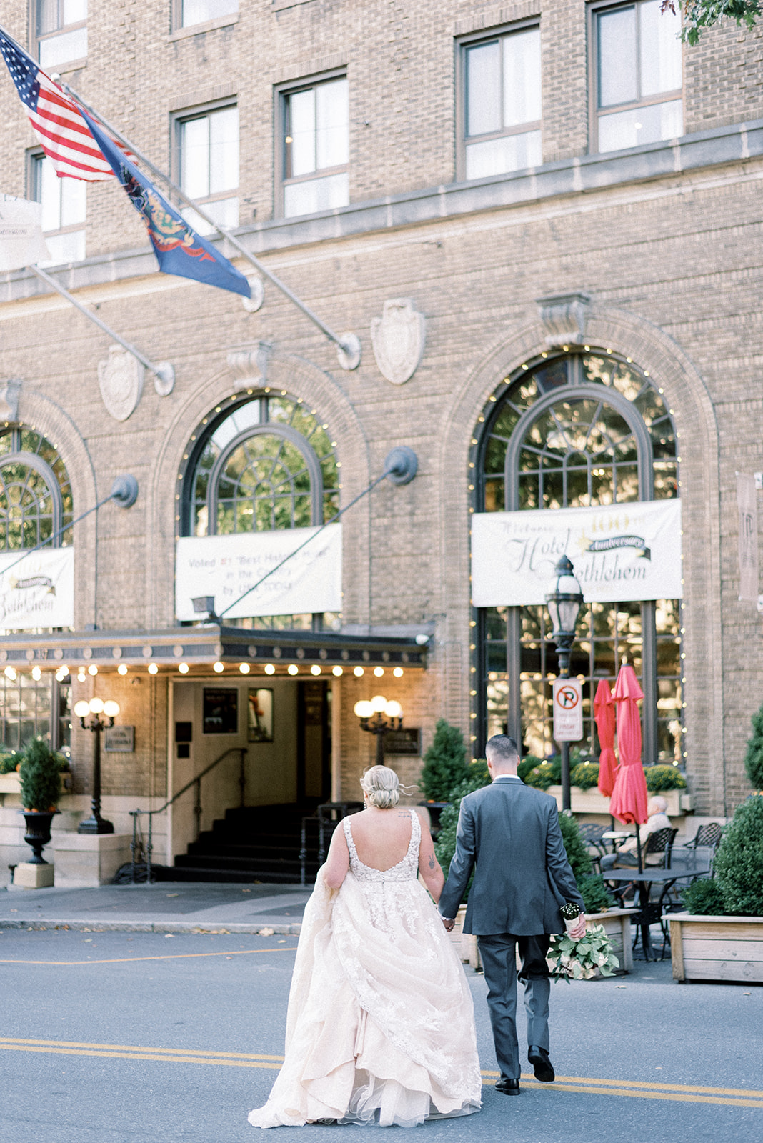 Pennsylvania wedding photographer captures couple walking across street to hotel after wedding ceremony