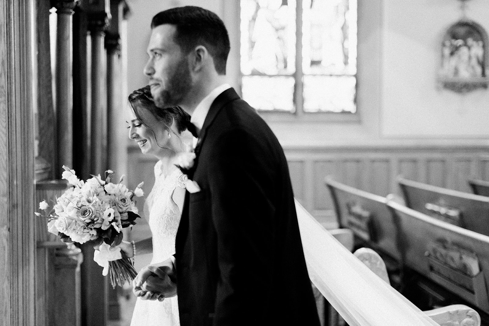 Pennsylvania wedding photographer captures black and white portrait of bride and groom leaving ceremony