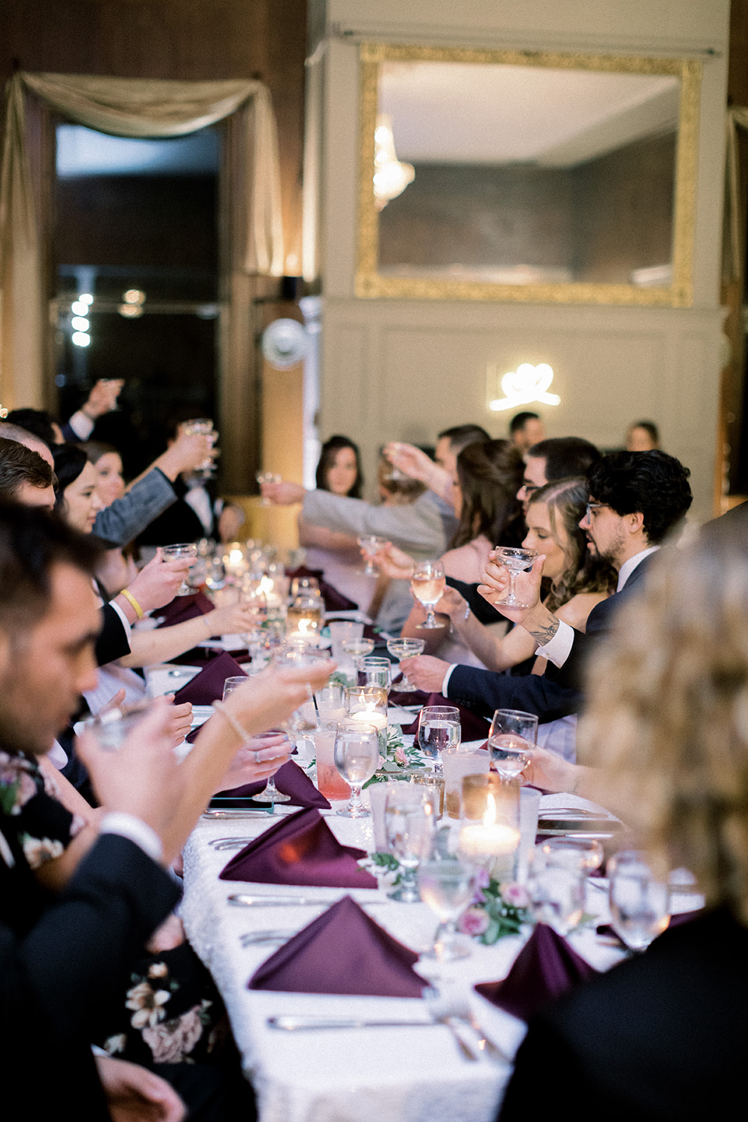 Pennsylvania wedding photographer captures indoor wedding reception with guests toasting